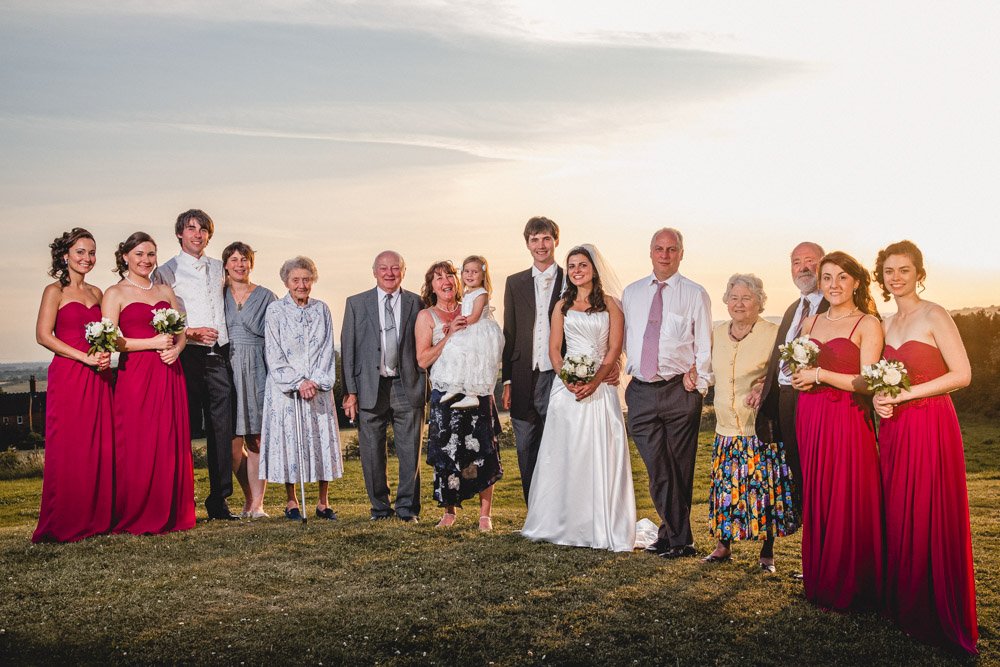 large family group shot with a beautiful sunset behind
