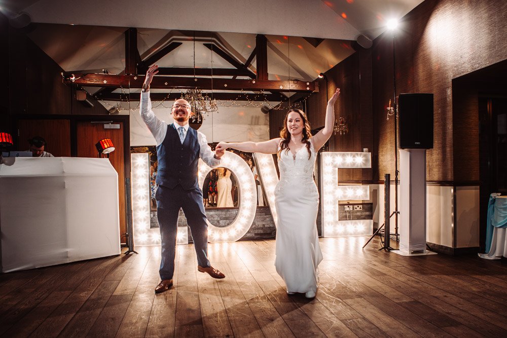 bride and groom wave to guests after their first dance