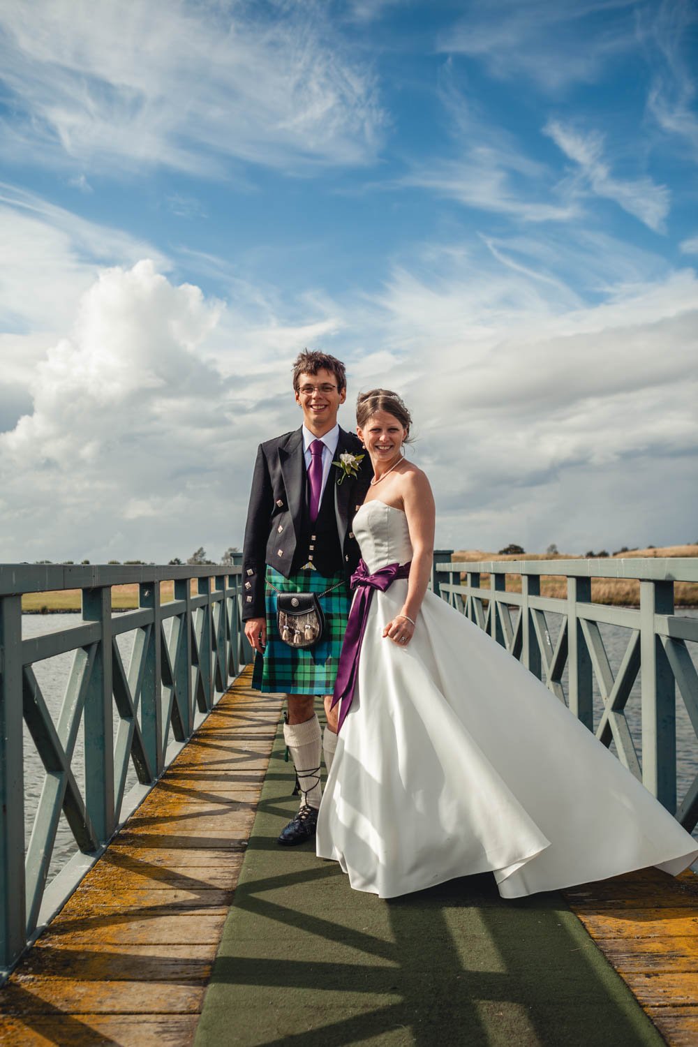 bride and groom stand on bridge at Oxfordshire golf course
