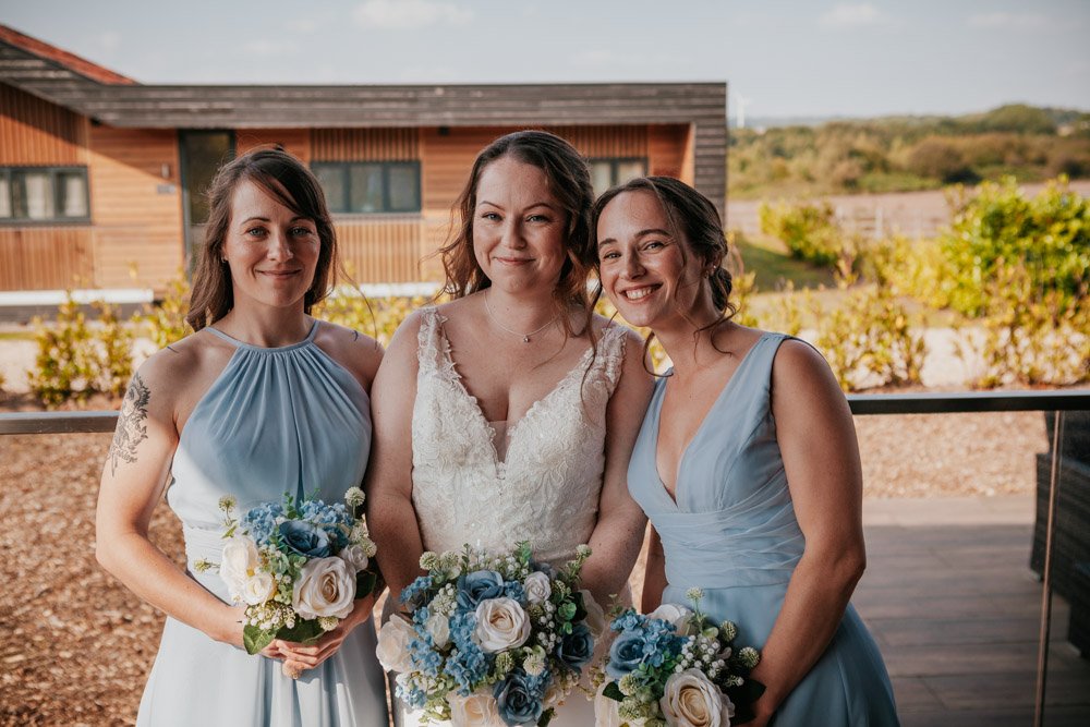 bridesmaids stand close to bride at Goosedale Lodges