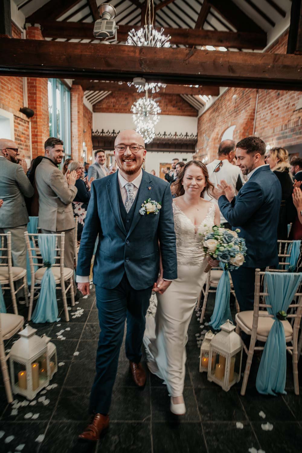 bride and groom walk up the aisle smiling in Crystal Hall ceremony at Goosedale
