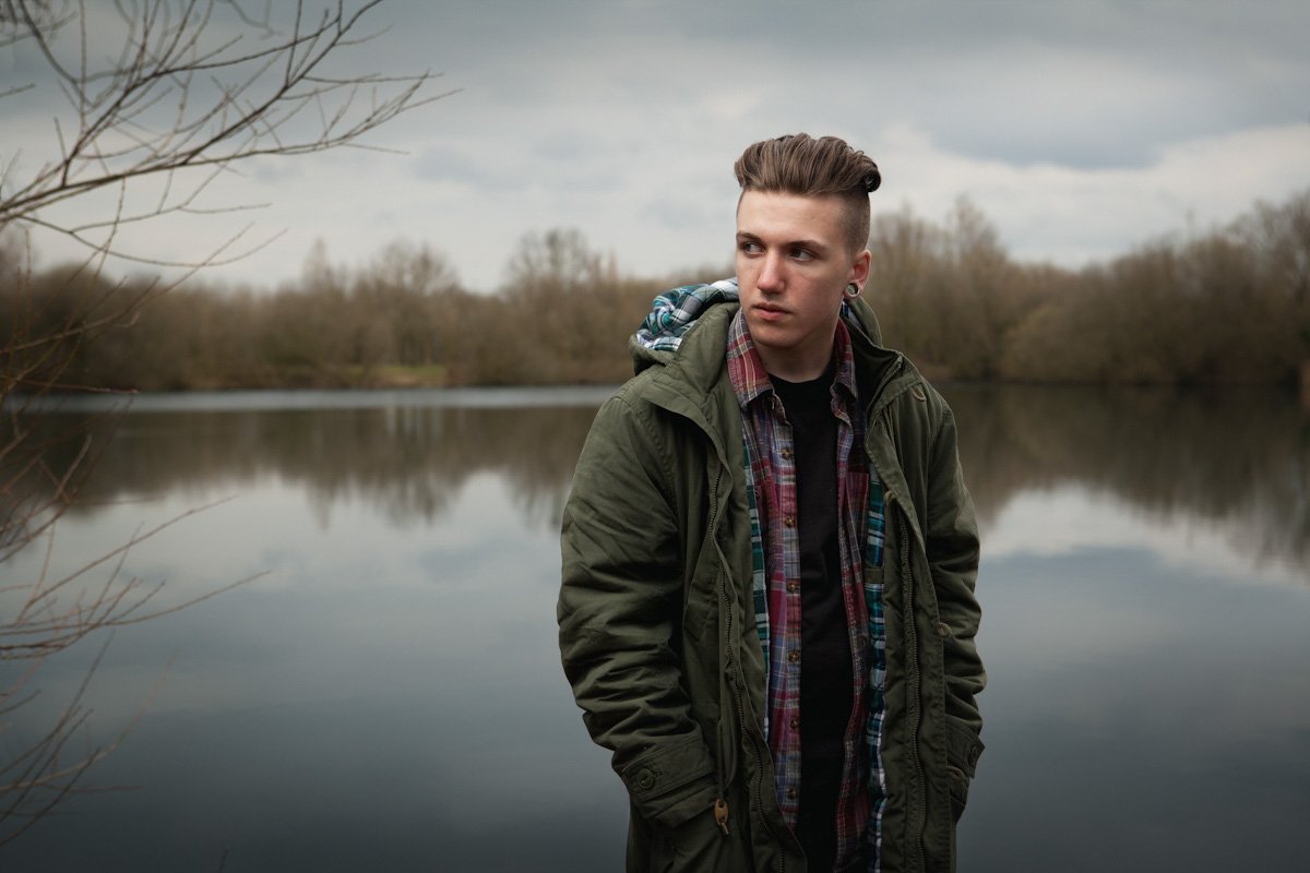 Songwriter Joey Knight stands next to a lake