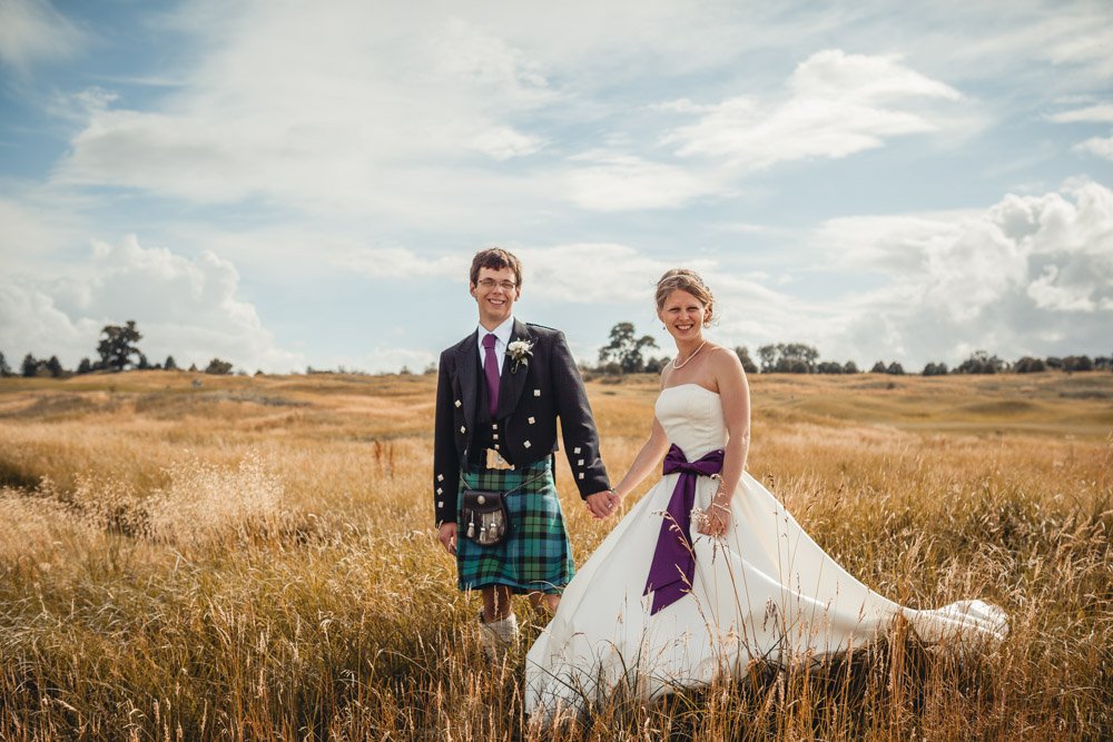 Bride and groom stand in grassy meadow at Oxfordshire Golf Course