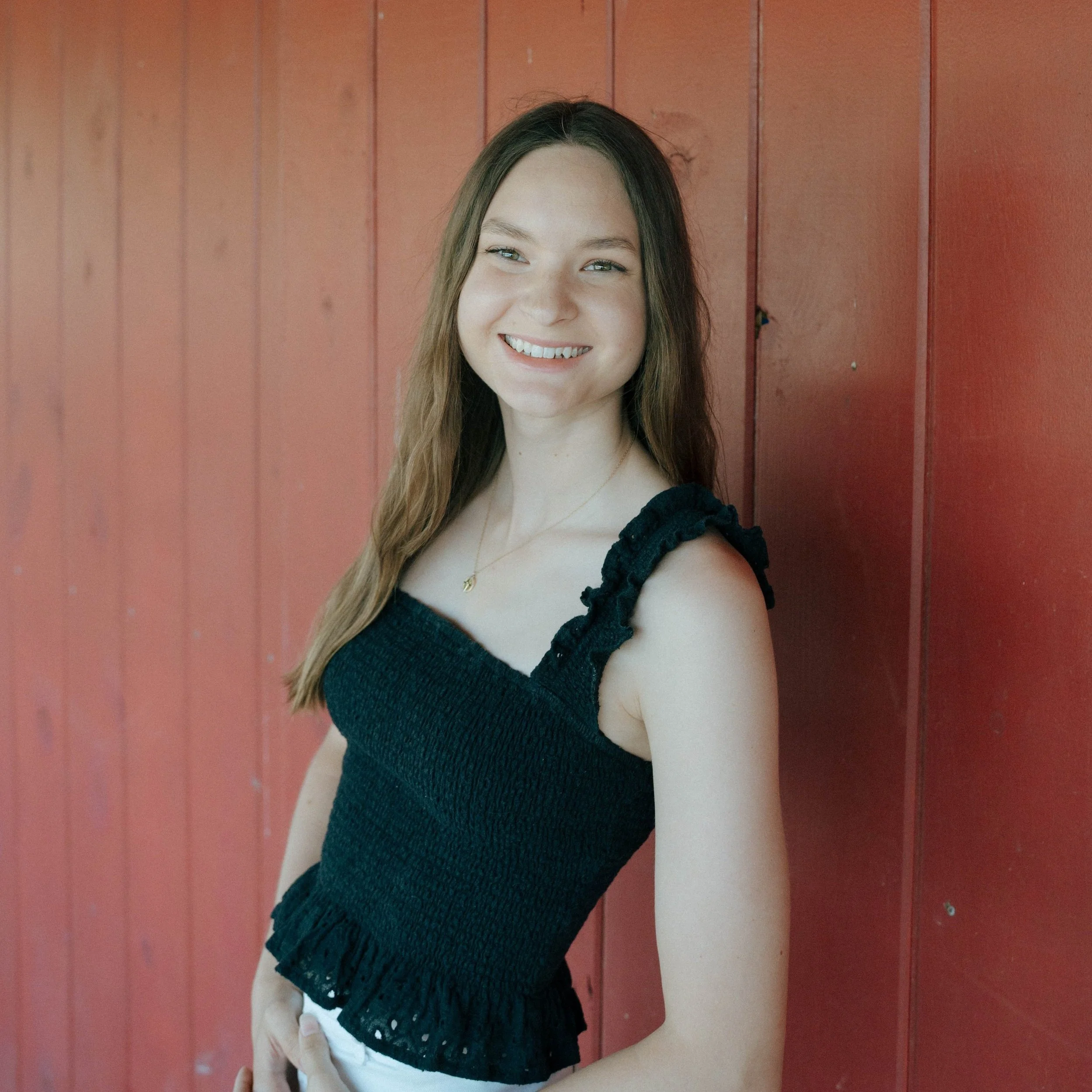 Smiling woman with brown hair wearing a light-colored blouse