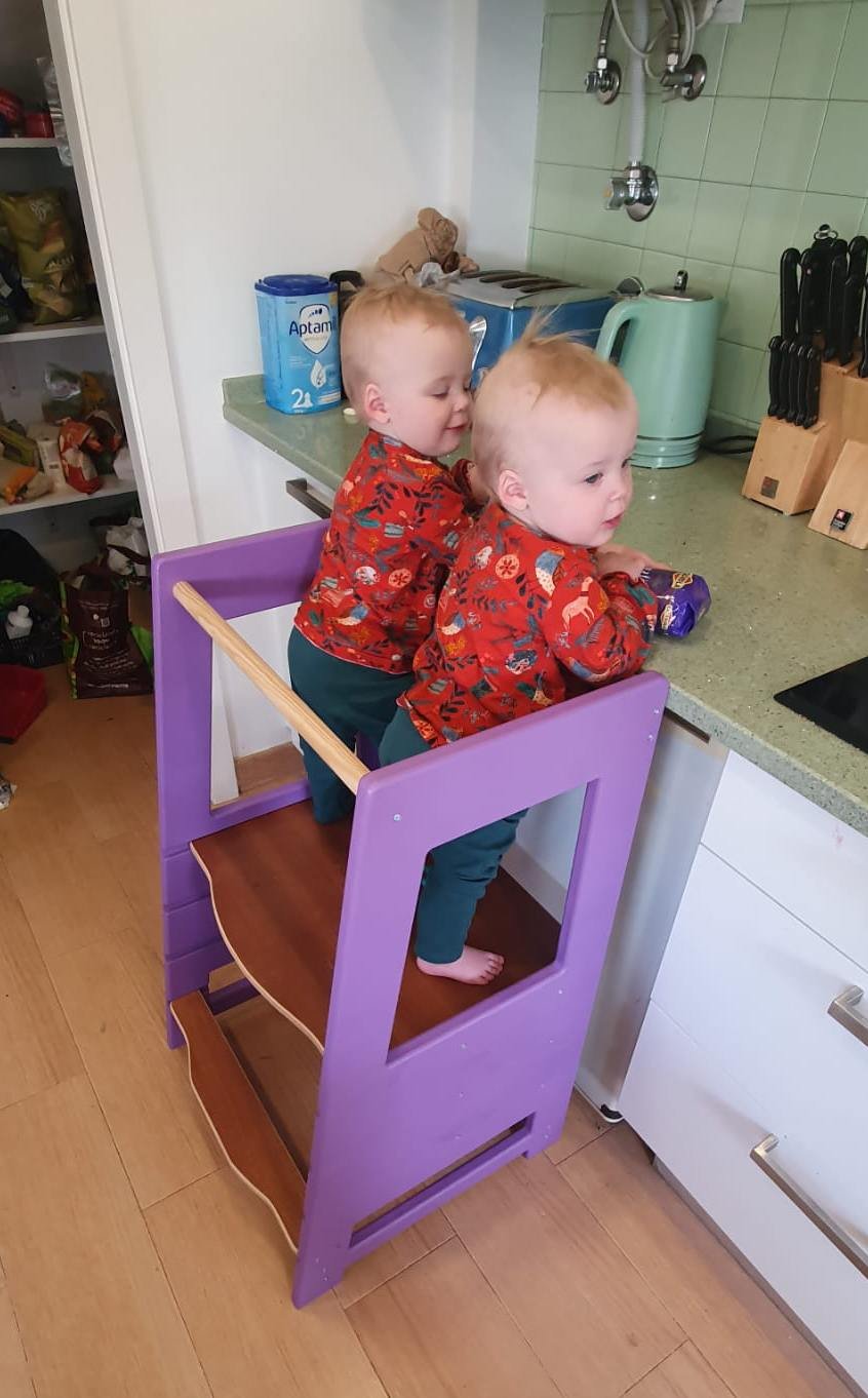 Montessori Kitchen Stool in Use - A child using a Montessori kitchen stool to assist in meal preparation, promoting independence.