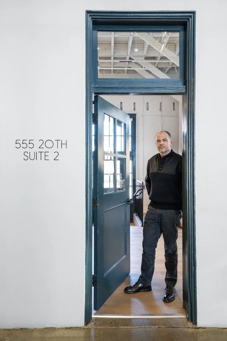 Adam Gould looking out from the open door to his office at 555 20th, Suite 2