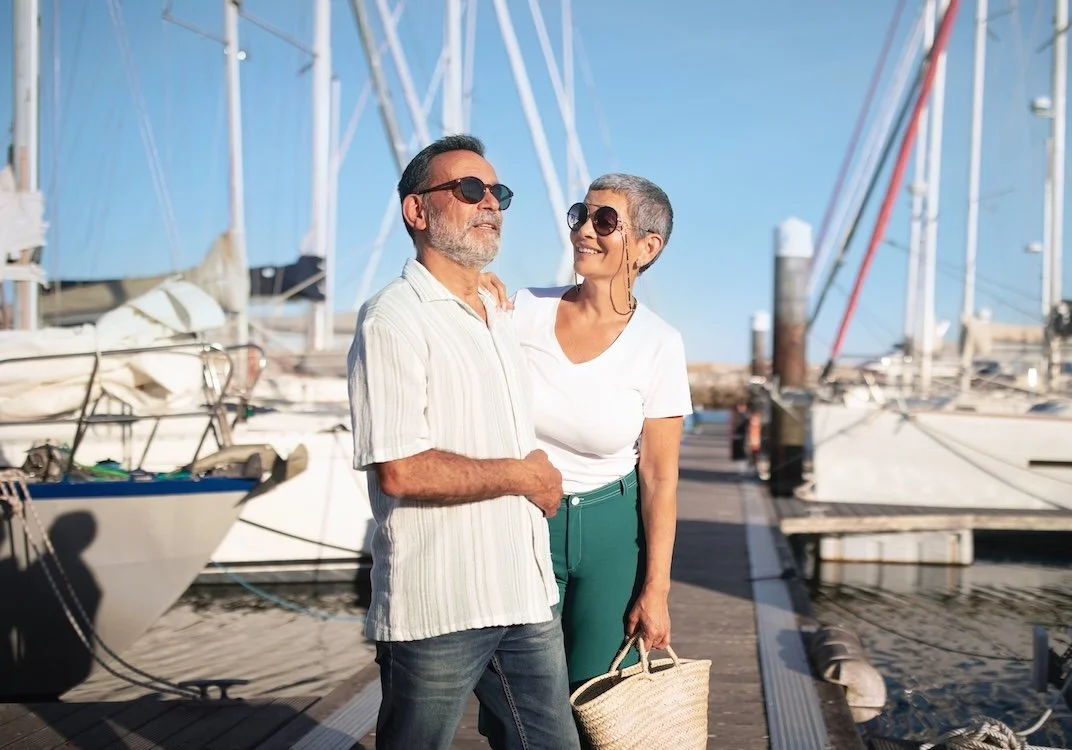 Elegant retired couple wearing sunglasses going sailing