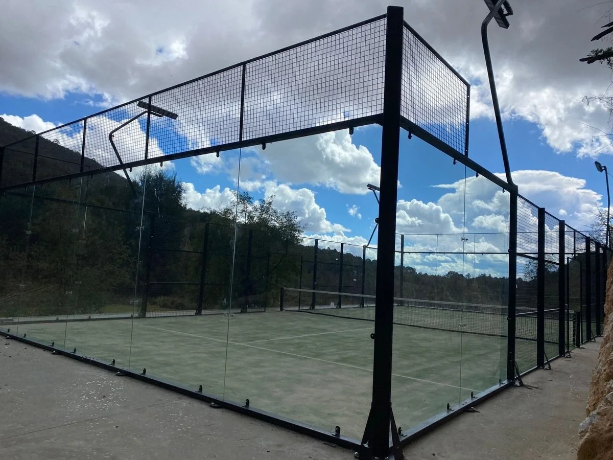 Vaxta Panor&aacute;mica PowerCube entregada en Bosque Tres Piedras. Estructura negra, pasto verde. 

Una cancha con dise&ntilde;o &uacute;nico e innovador; resistente y duradera; con iluminaci&oacute;n premium tipo Premier P&aacute;del y pasto rizado