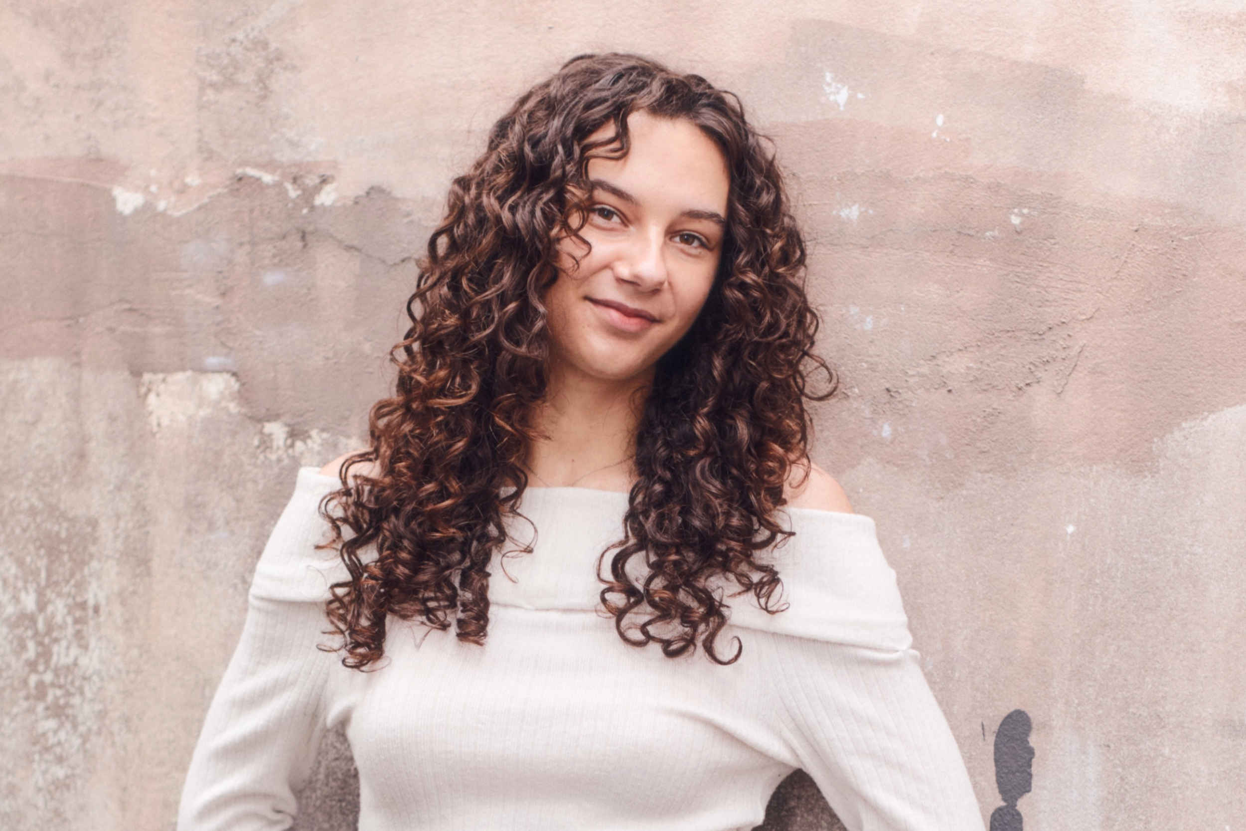 Neisha after her curly hair transformation at Gato Loco Hair, showing defined, bouncy curls with soft volume.