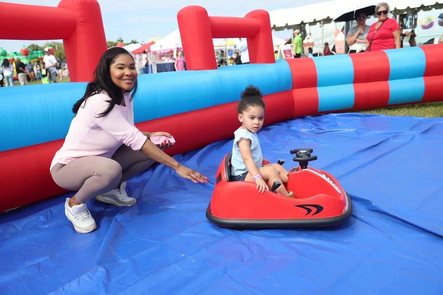 Kids riding an inflatable bumper car course from FOMO Bounce