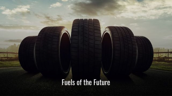 Five large car tires lined up outdoors with the text 'Fuels of the Future' at the bottom, against a cloudy sky background.