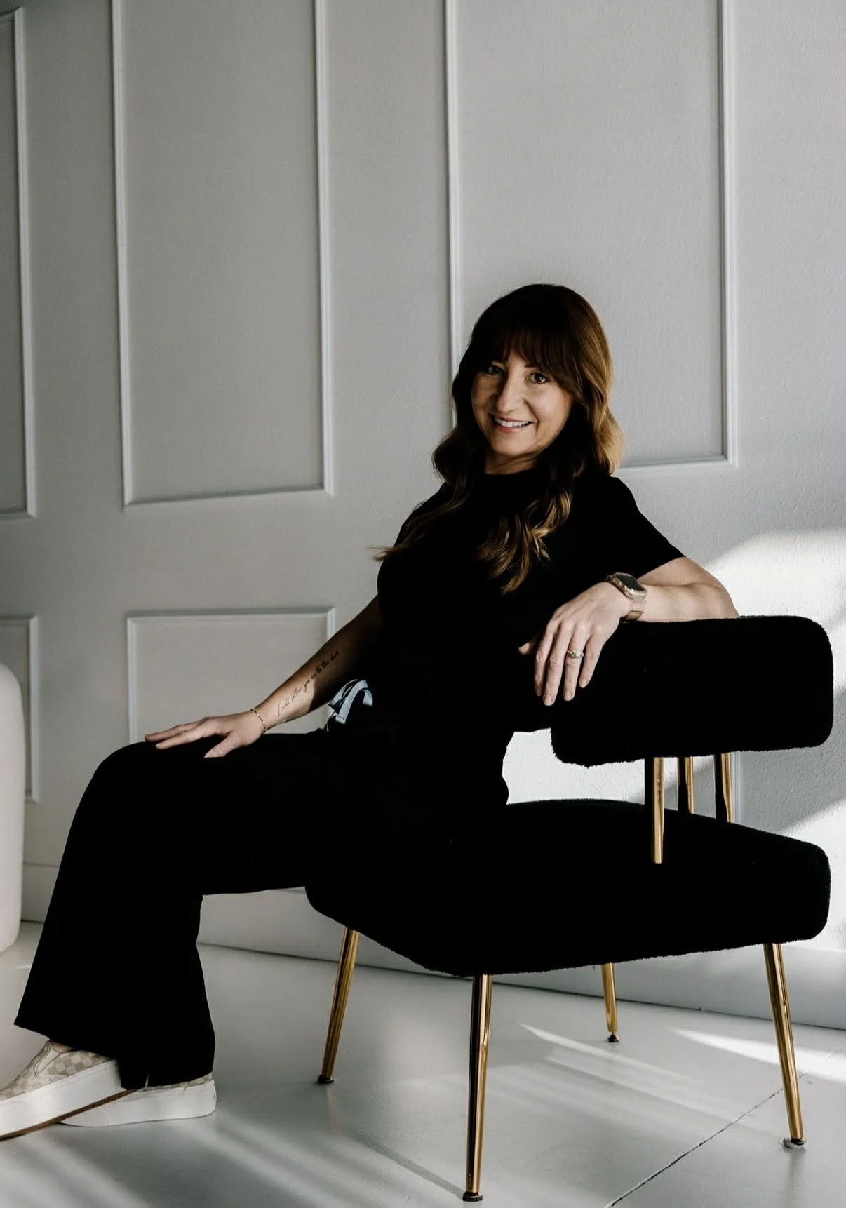 Carli of LUXE Whitening Lounge smiling, welcoming clients to a professional teeth-whitening experience.