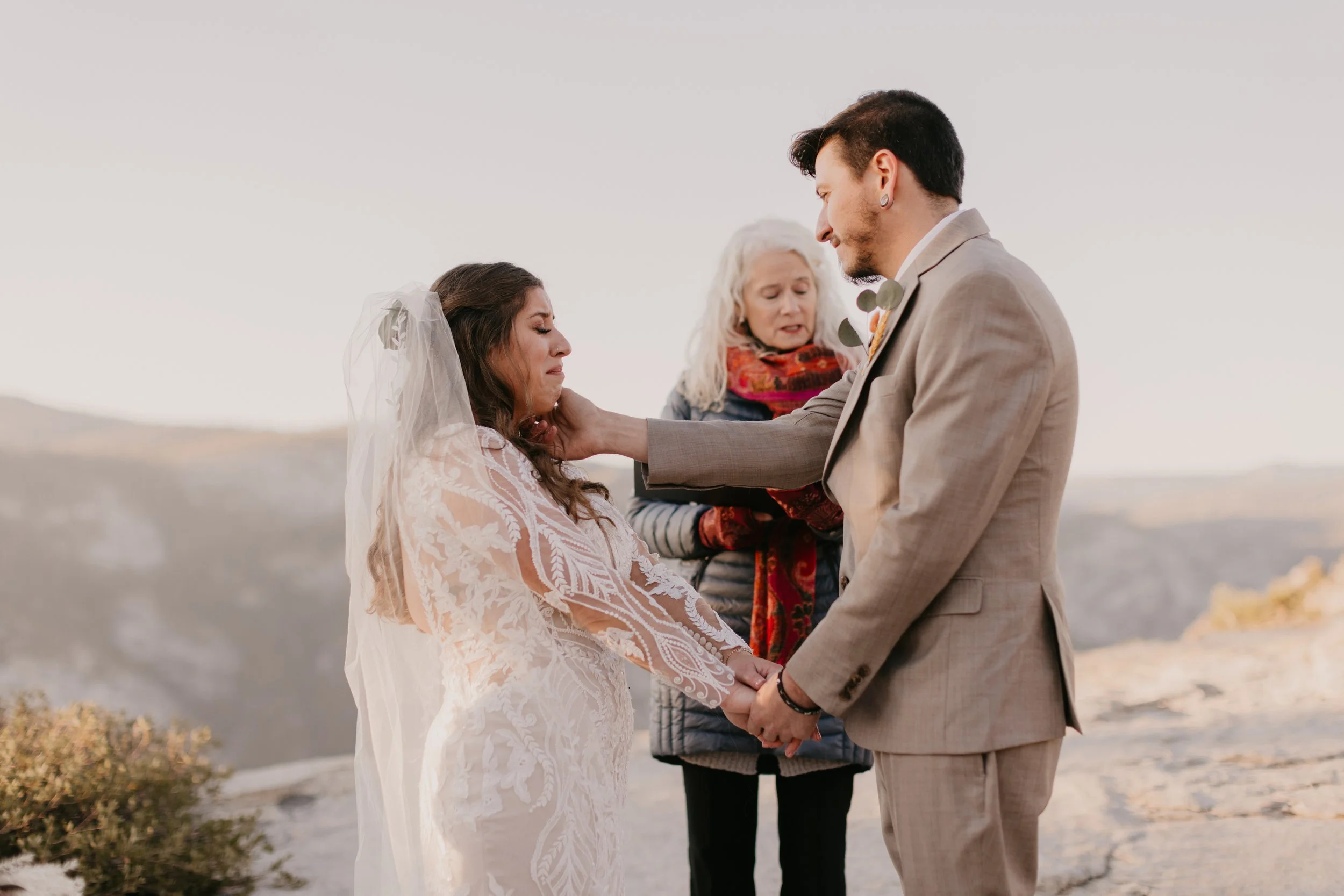 Wedding Couple Portrait during ceremony. Brides tears are wiped by groom in Yosemite.