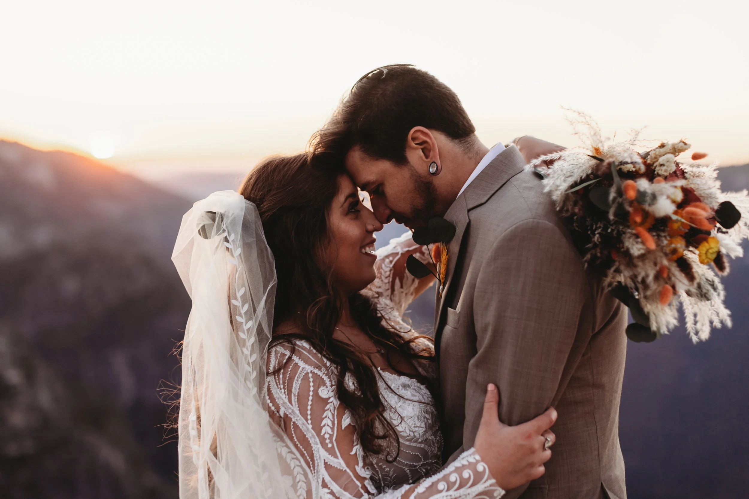 Wedding couple posing on Yosemite Park cliffside during golden hour.