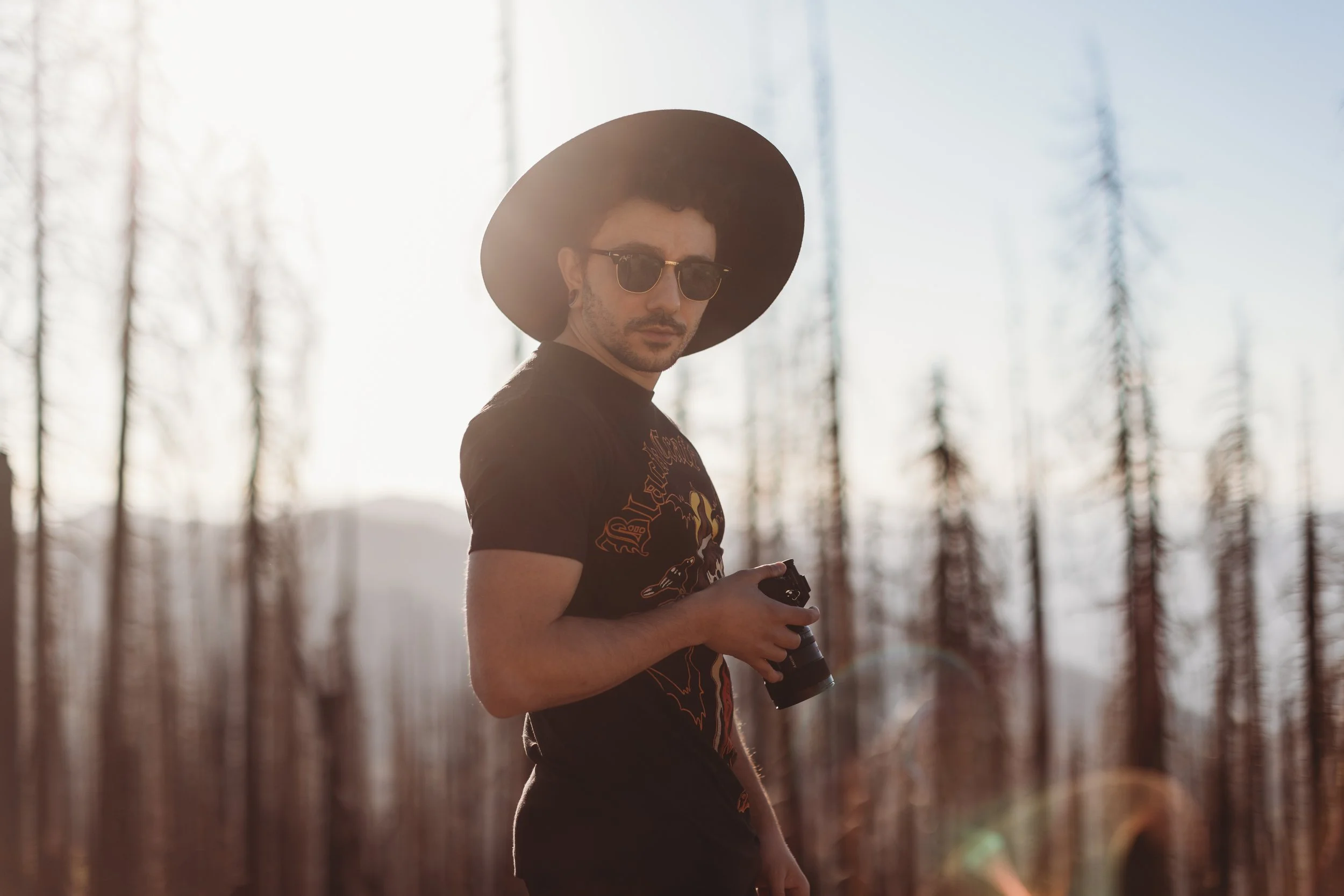 Alternative Male Photographer posing with camera in Yosemite.