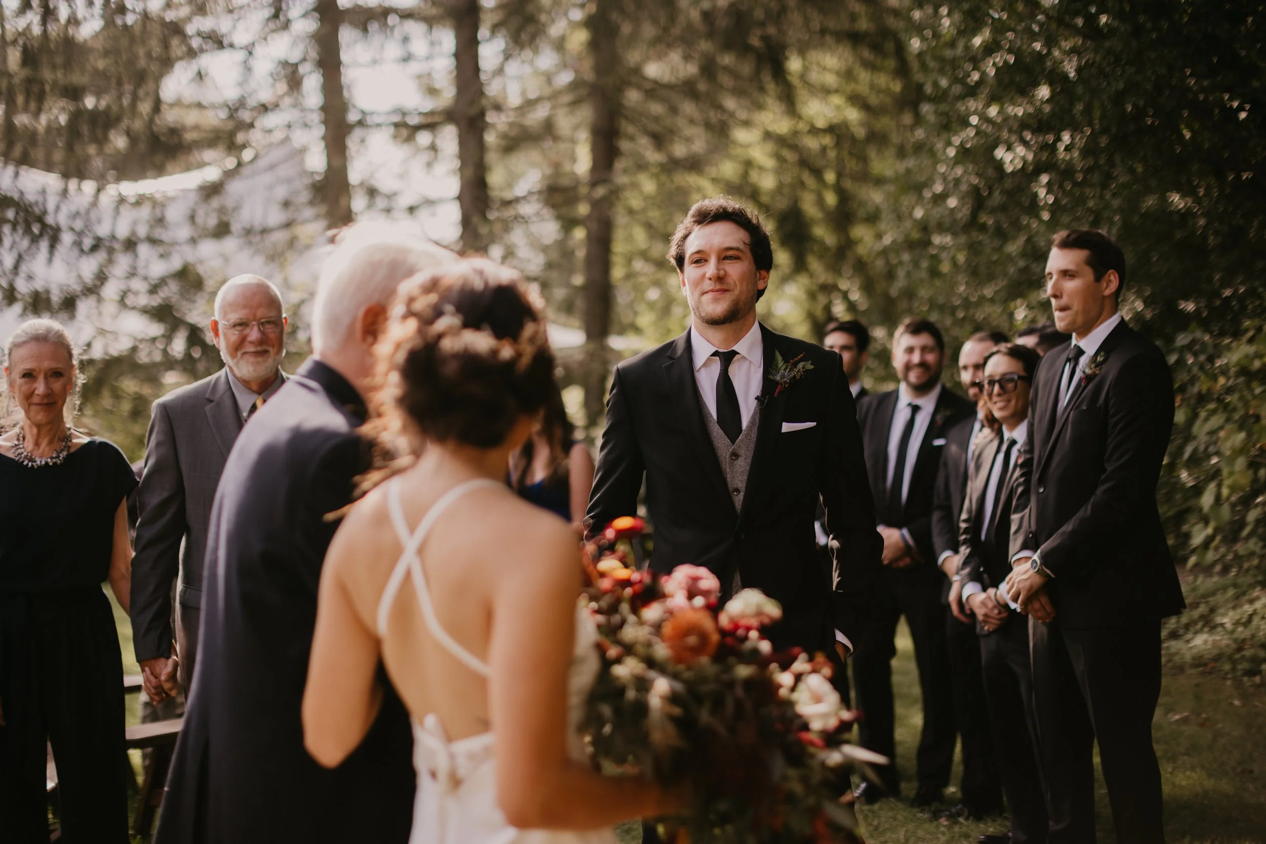 Father leading Bride down aisle to groom. Groom holds back tears during wedding ceremony.