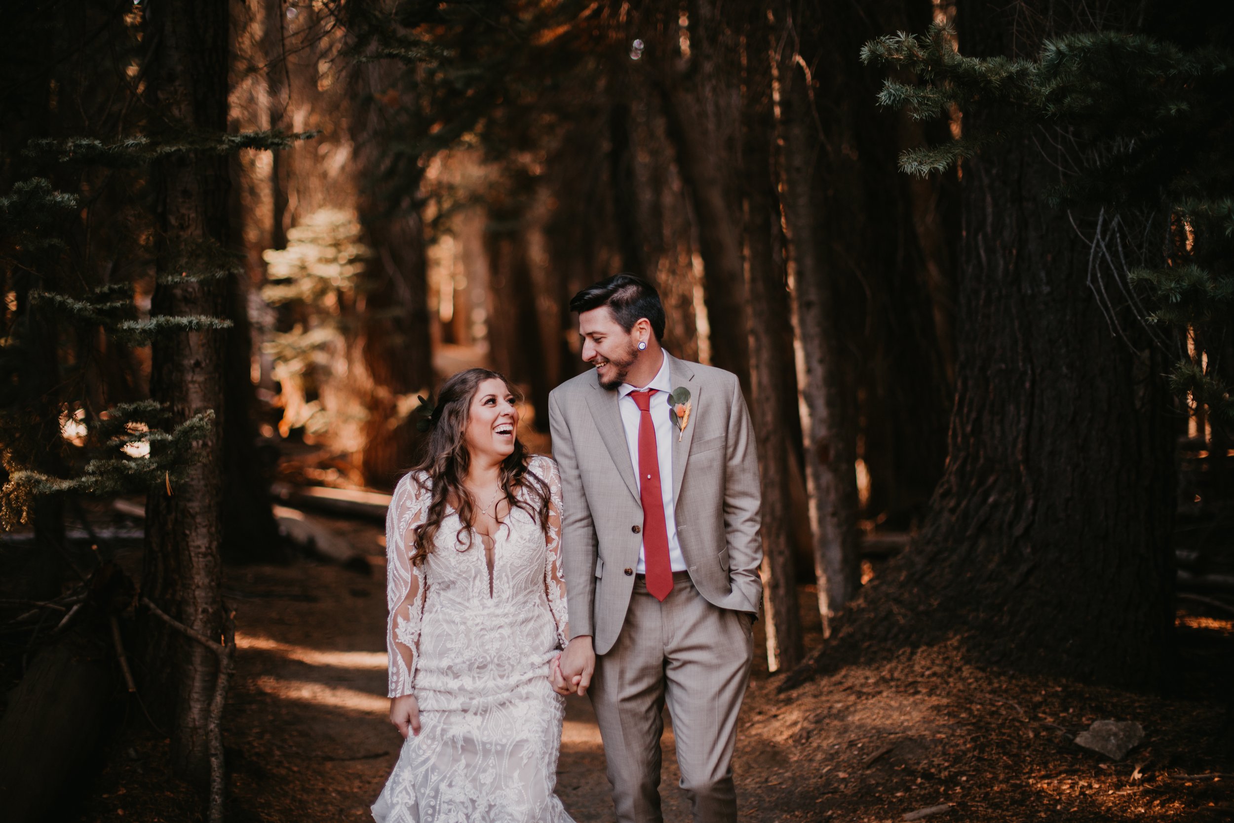 Wedding Couple walking through trees in Yosemite National Park.
