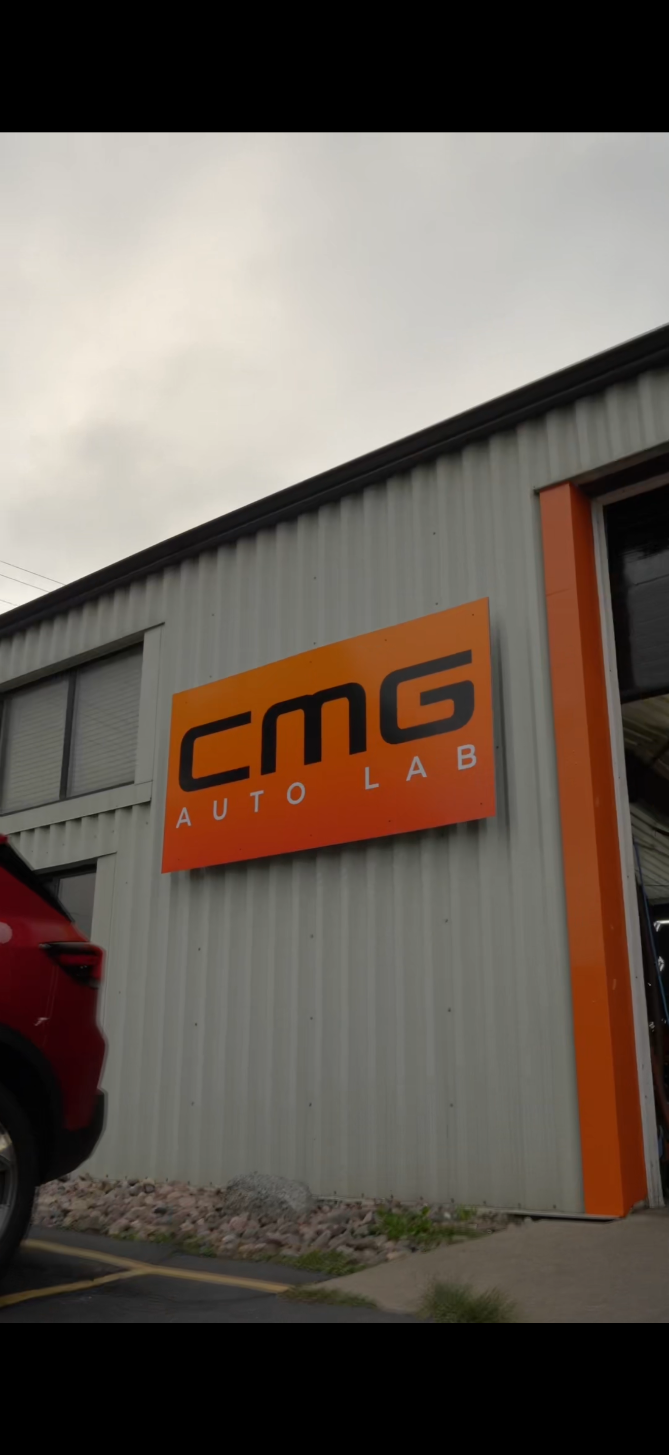 Sign for CMC Auto Lab on the exterior wall of an industrial building