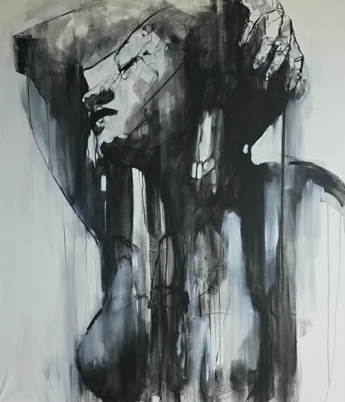 Black and white abstract painting of a person with a hand on their forehead, showing a somber or introspective mood.
