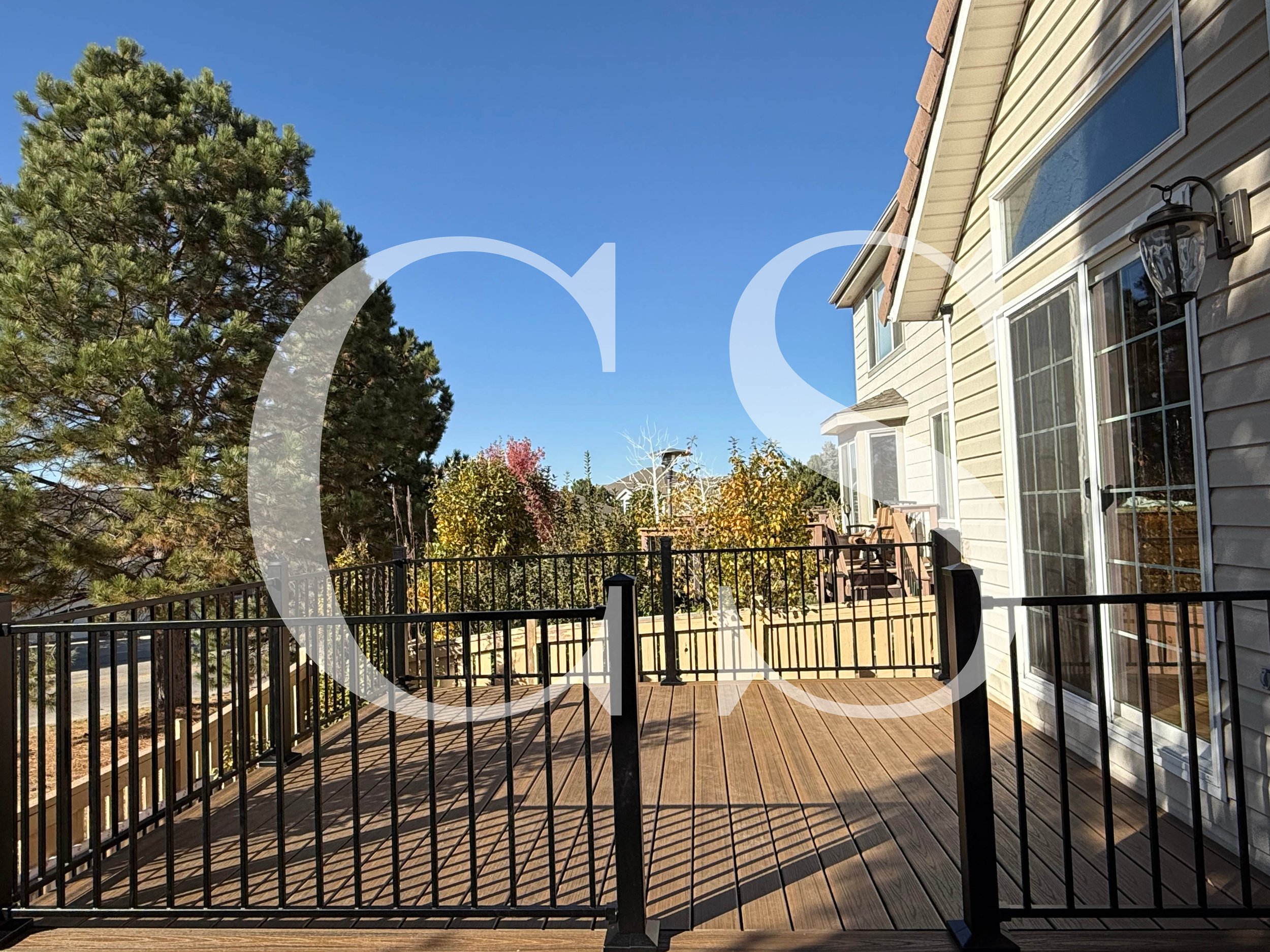Stylish and secure—this backyard deck with wrought iron rails is designed for relaxation and refined outdoor living.