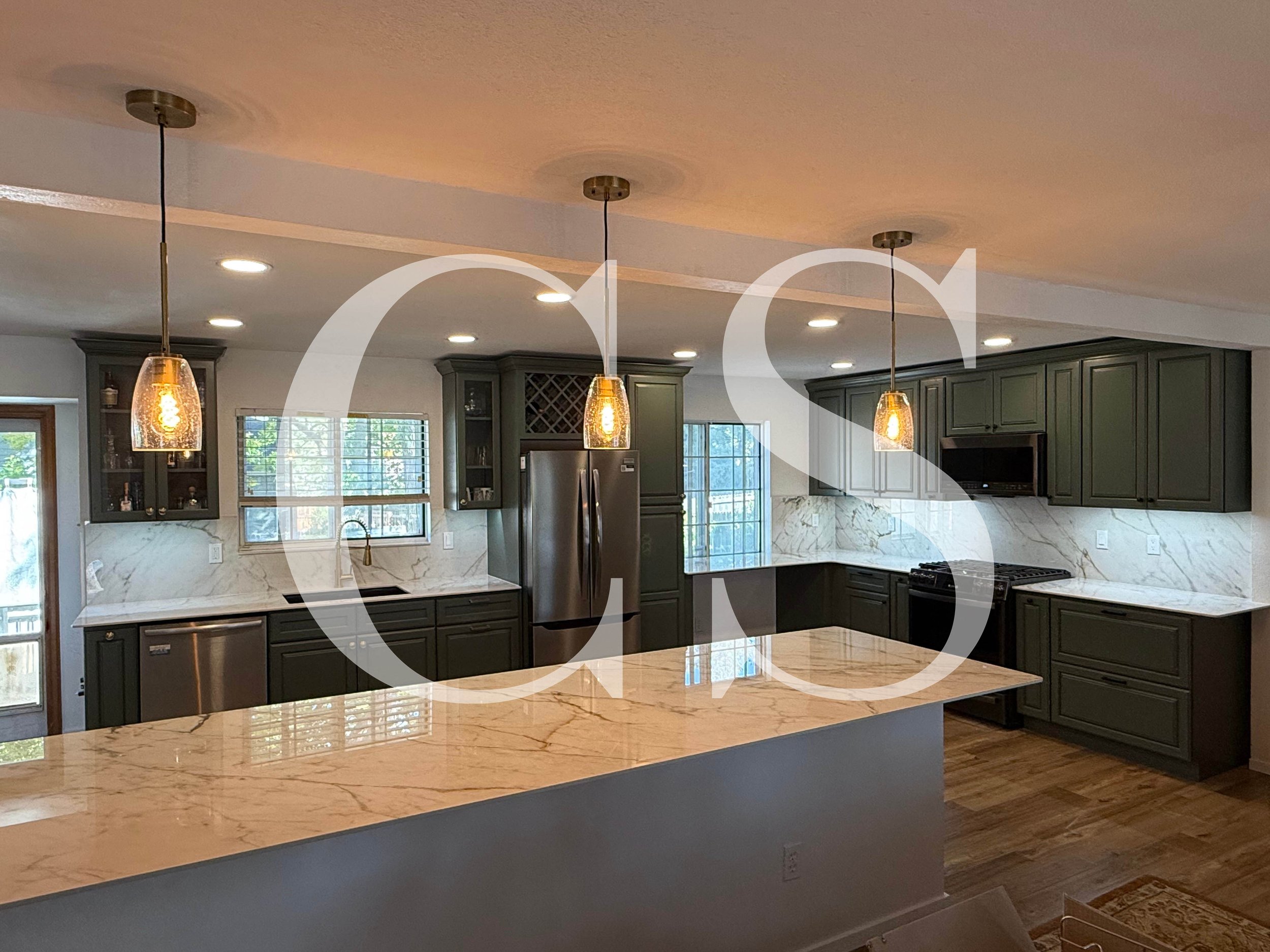 Beautiful kitchen cabinets paired with elegant pendant lighting installation create a warm and inviting space with a touch of luxury and practicality.