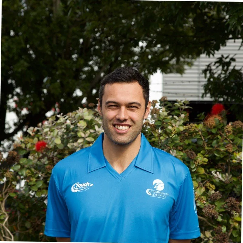 Josh is wearing a blue shirt, smiling in an outdoor setting