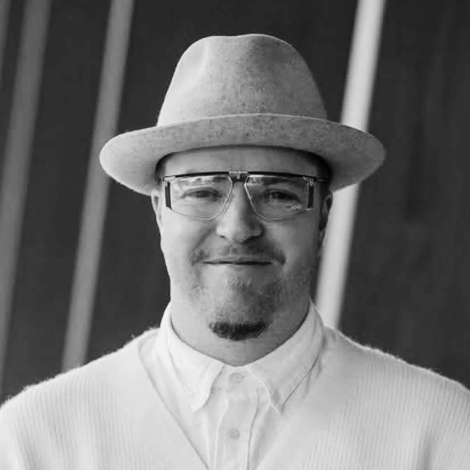 Picture of Dujon Cullingford smiling, he's wearing glasses and a hat