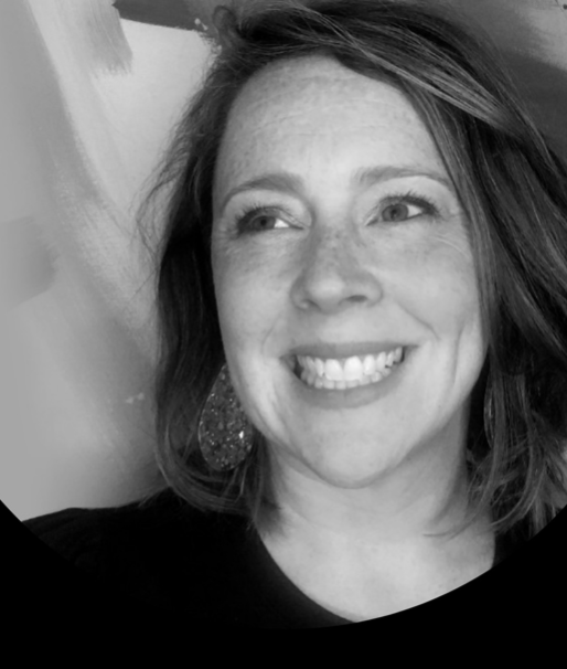 Close-up black and white photo of a woman smiling and looking to her left, with shoulder-length hair and earrings.