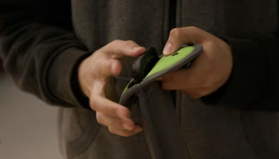 A person is holding and using a smartphone with a bright yellow case.