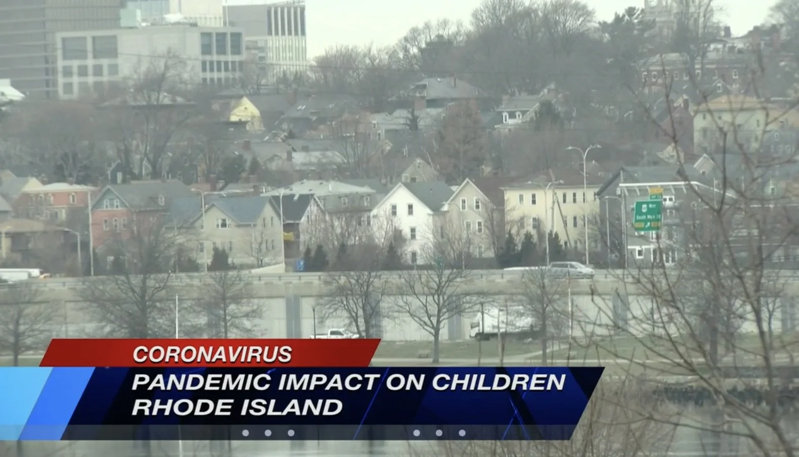 A cityscape of Rhode Island with trees and buildings, overlaid with a news headline about the impact of the coronavirus pandemic on children.