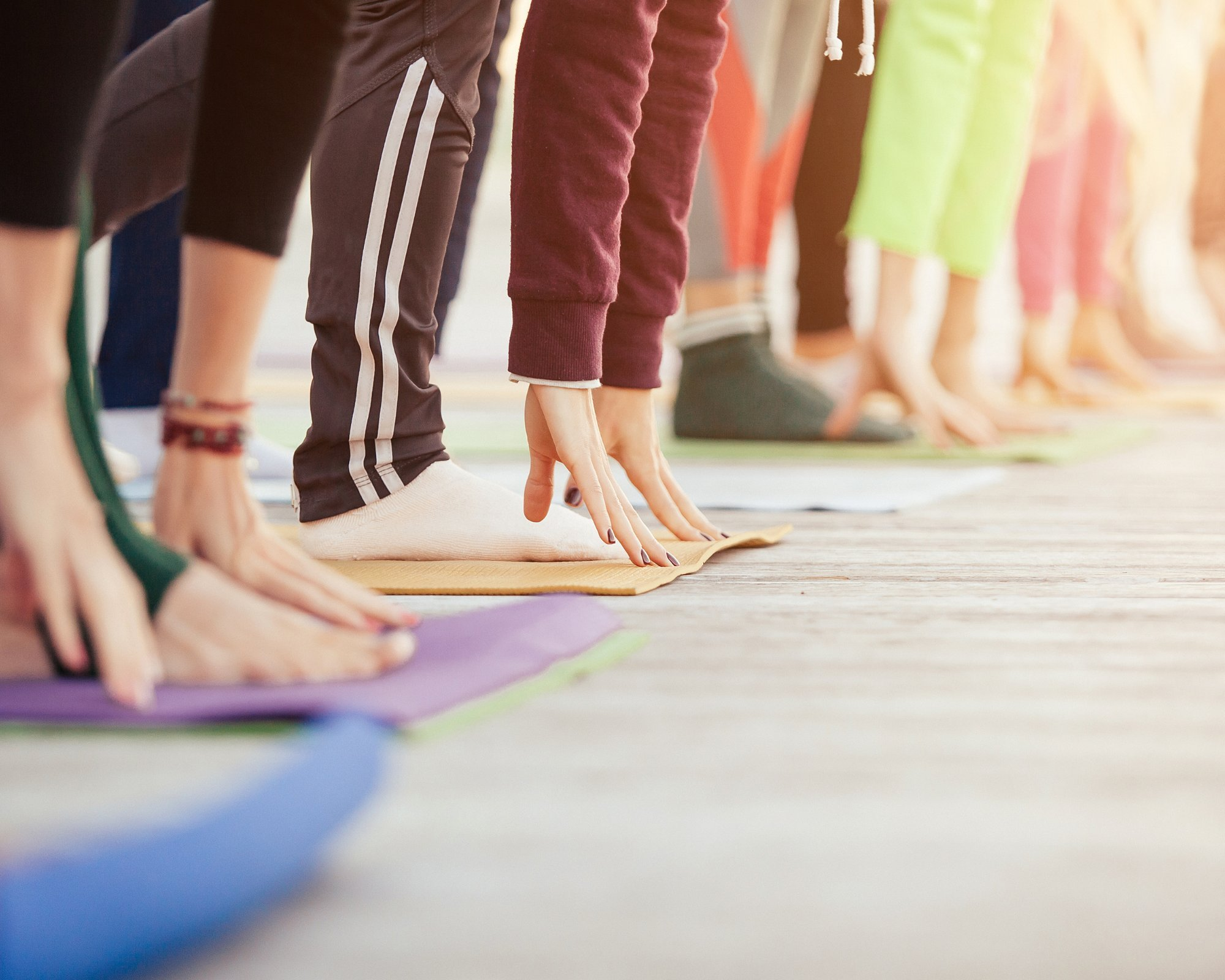 Group performing yoga poses on mats.