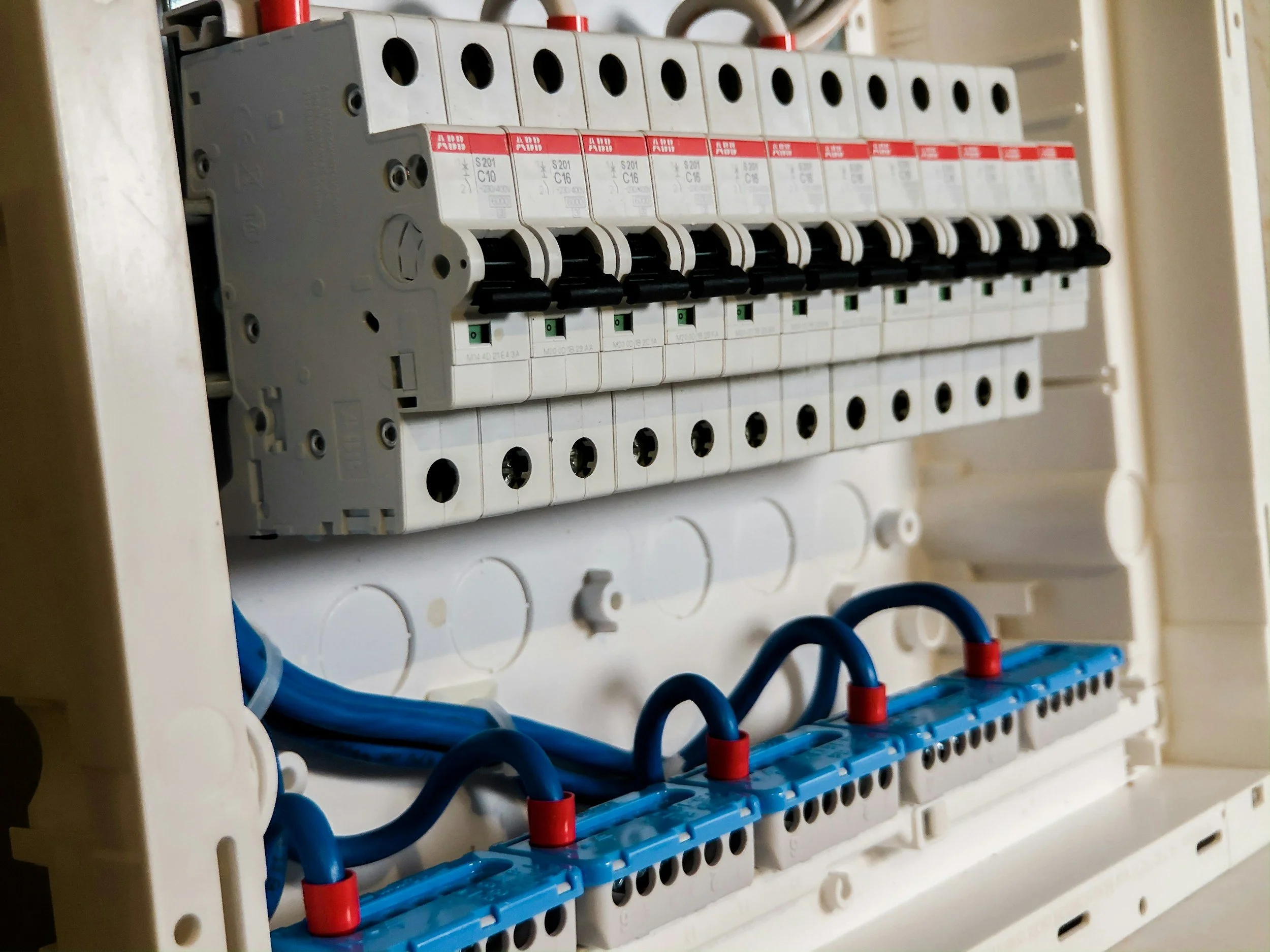 An electrical circuit breaker panel with multiple switches, wires, and electrical connections.