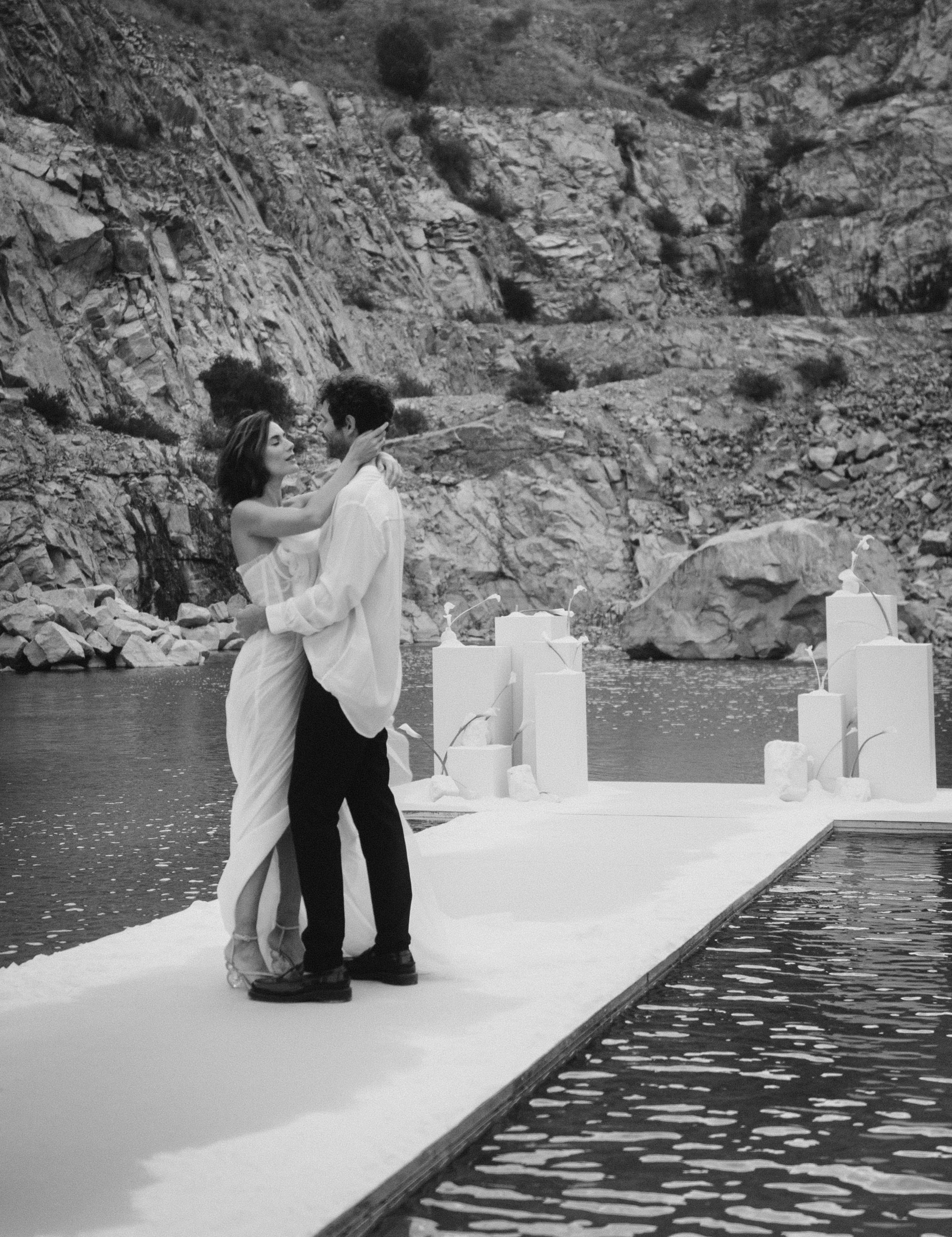 Brautpaar umarmt sich auf weißem Steg im See – Elopement Hochzeit (schwarzweiß)
Beschreibung: Umarmung mitten im Wasser – ein ikonisches Motiv für Elopement-Hochzeiten: minimalistische Kulisse, starke Felsen, klare Linien. Perfekt für eine besondere 