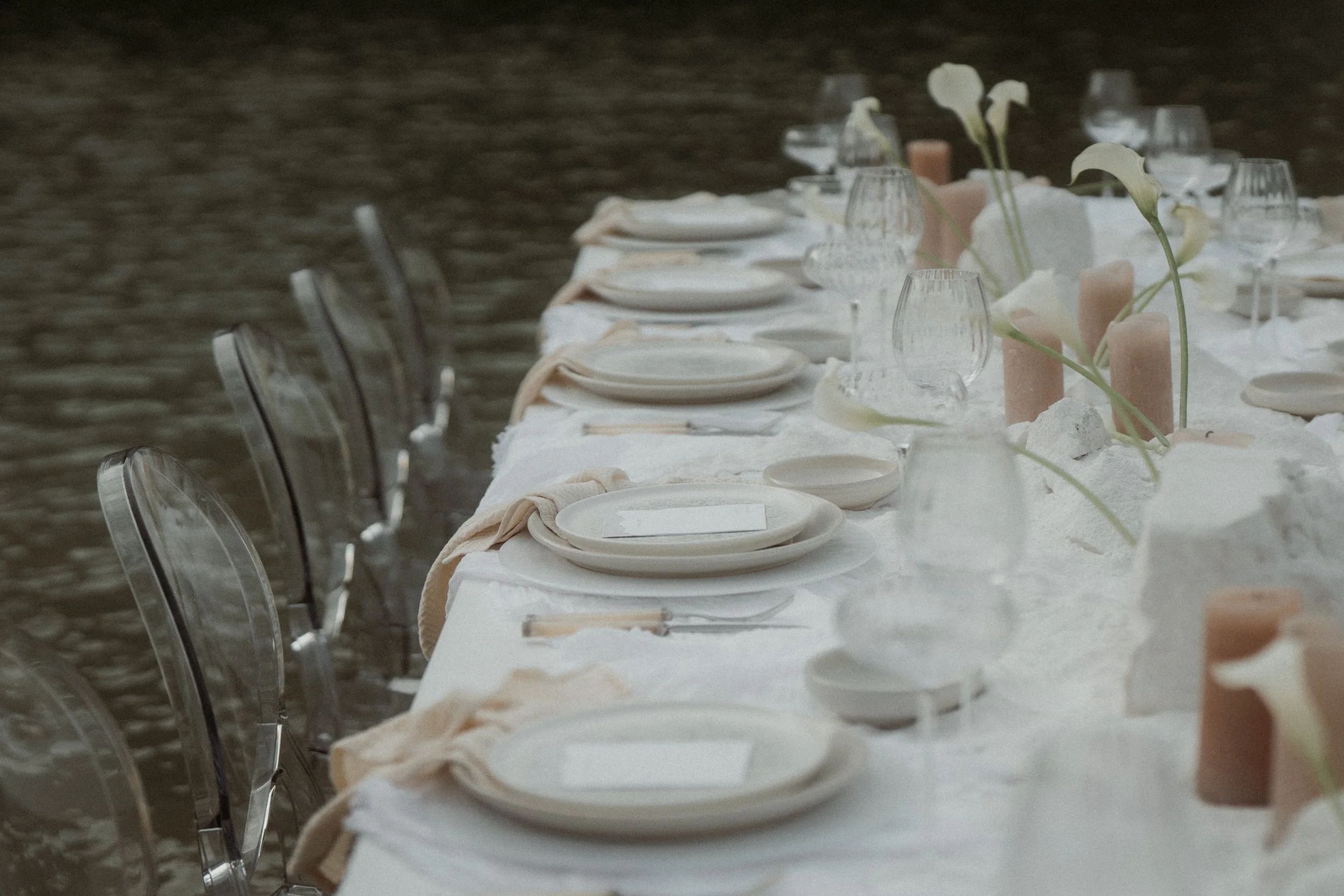 Gedeckte Tafel am Wasser mit transparenten Stühlen und Kerzen – Elopement Wedding Styling
Modernes Wedding-Dinner-Setting am Wasser: transparente Stühle, reduzierte Farbpalette, Kerzen und Calla-Lilien. Perfekt für Elopement-Hochzeiten und stilvolle 