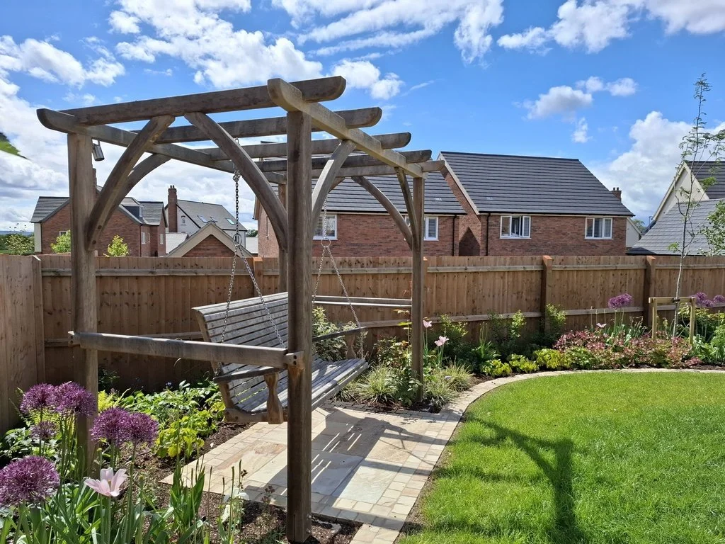 Sunshine and blue skies at our Sutton Bonington project installed in summer 2025. The garden is really filling out now, with plenty of colour and a beautiful bespoke oak pergola and a swing seat from Sitting Spiritually of Lyme Regis. The trees will 
