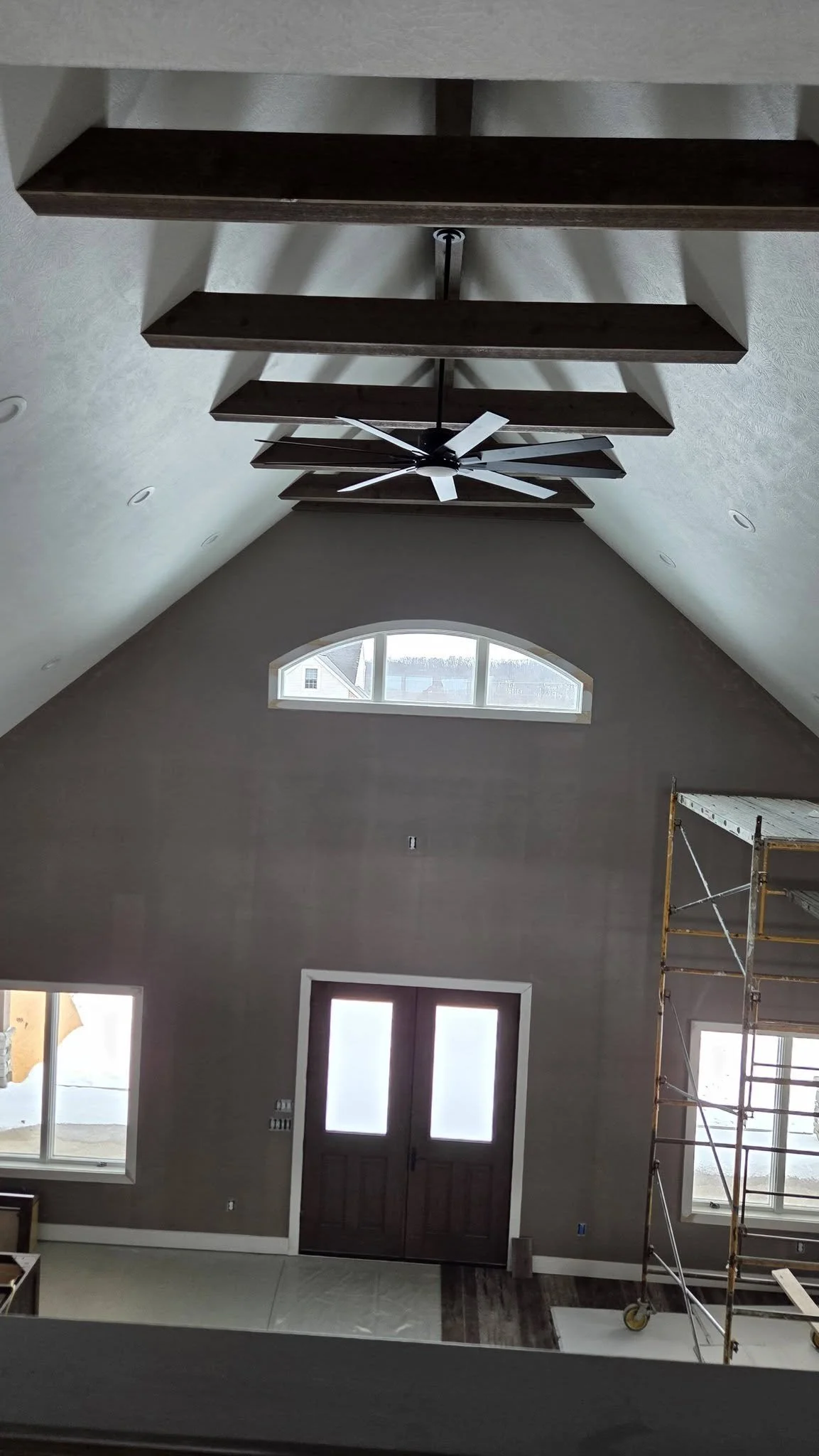 Vaulted ceiling with exposed wood beams in custom home great room