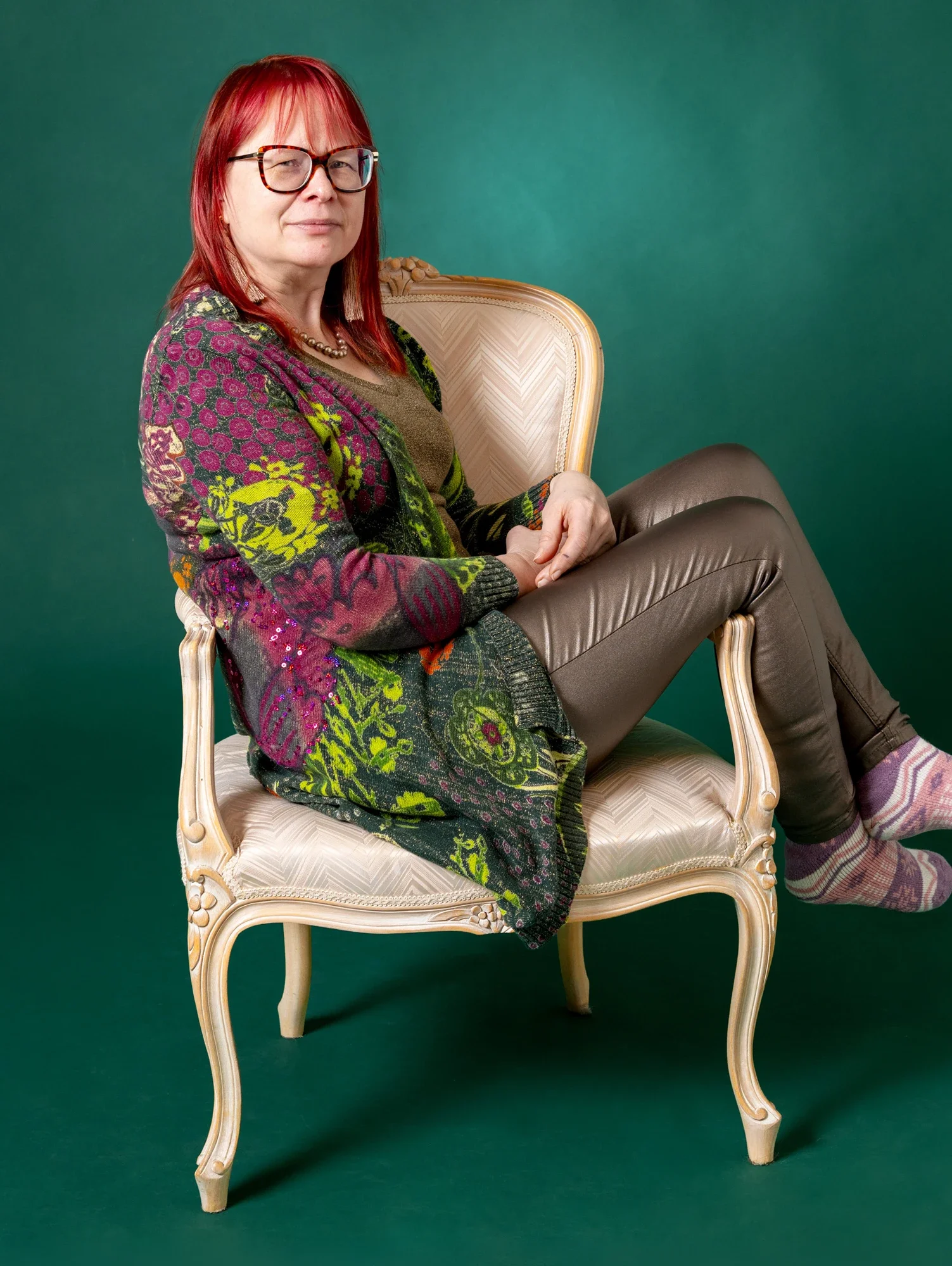 Verhoilija Irene Nieminen Verhoomo Kultatuolista istumassa klassisessa nojatuolissa.