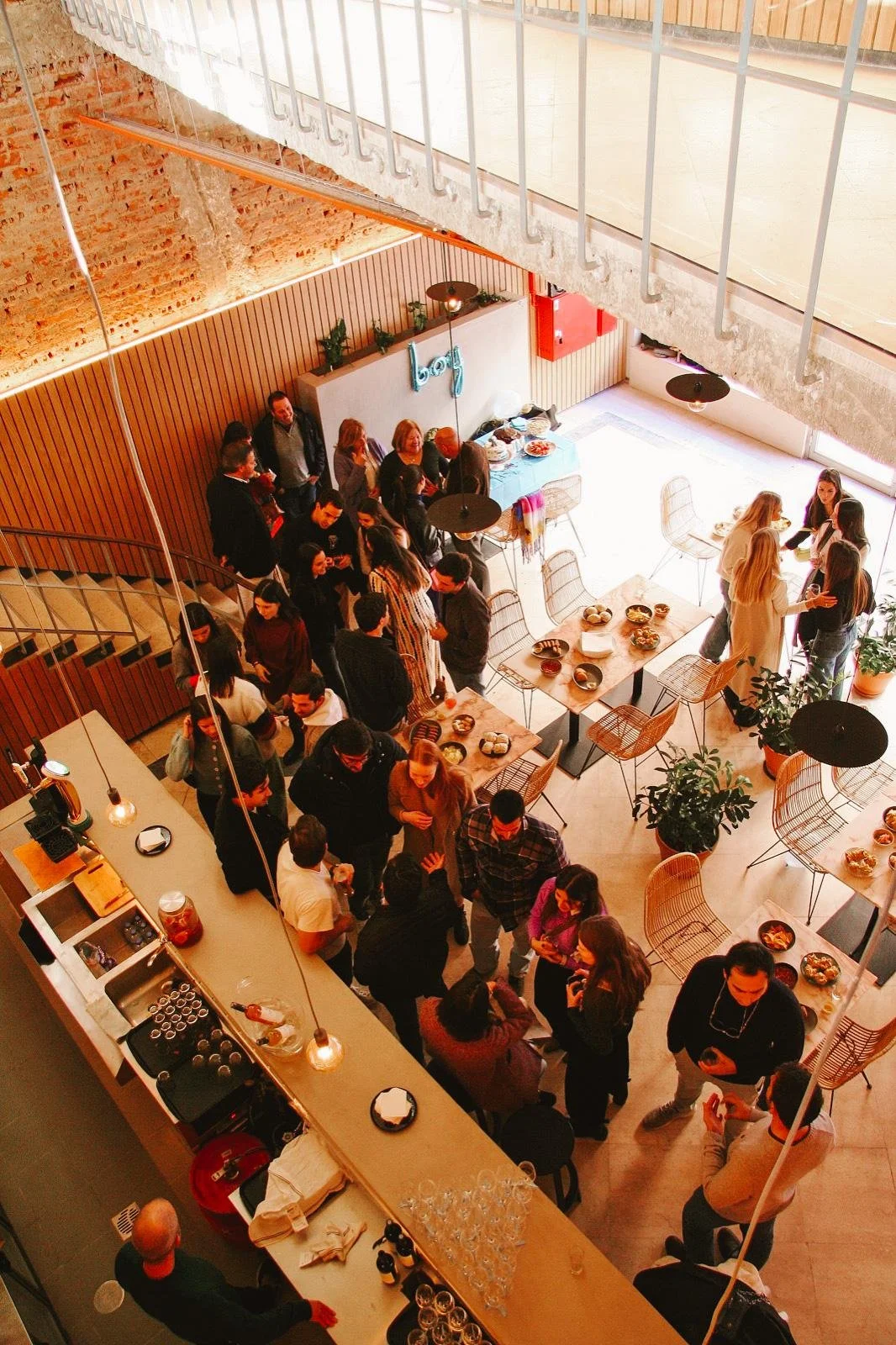 Evento privado no restaurante Cobaia em Alvalade, Lisboa, com grupos de pessoas, buffet e bar visto do primeiro andar.