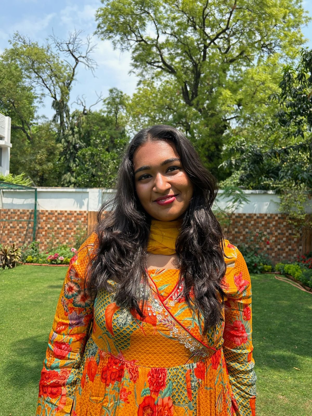 Woman with long dark hair in front of a tree