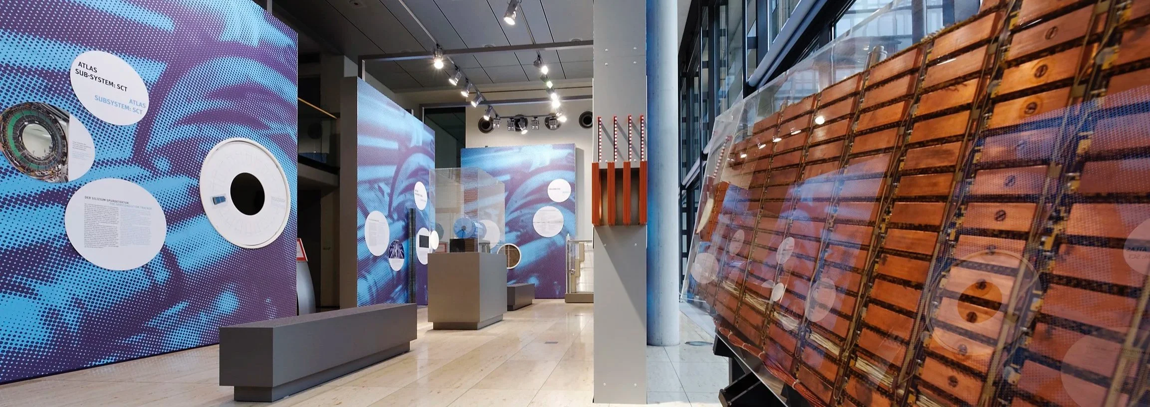 Ausstellung im Museum mit Displays und Texte über Atlanten, Satelliten und Raumfahrttechnik.