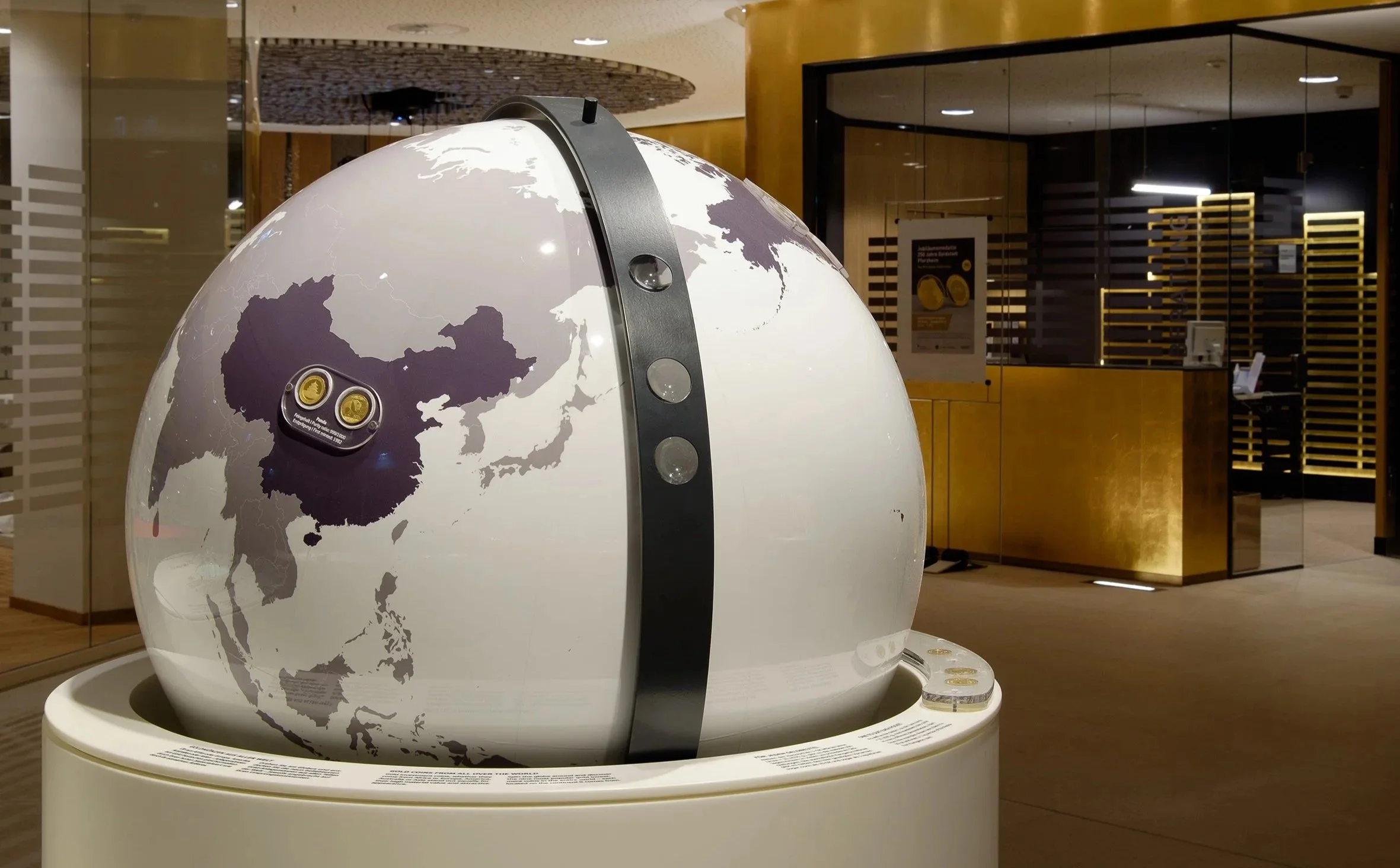 Ein Globus mit einer Karte von Asien, der auf einem Ausstellungsstand in einem Museum steht.