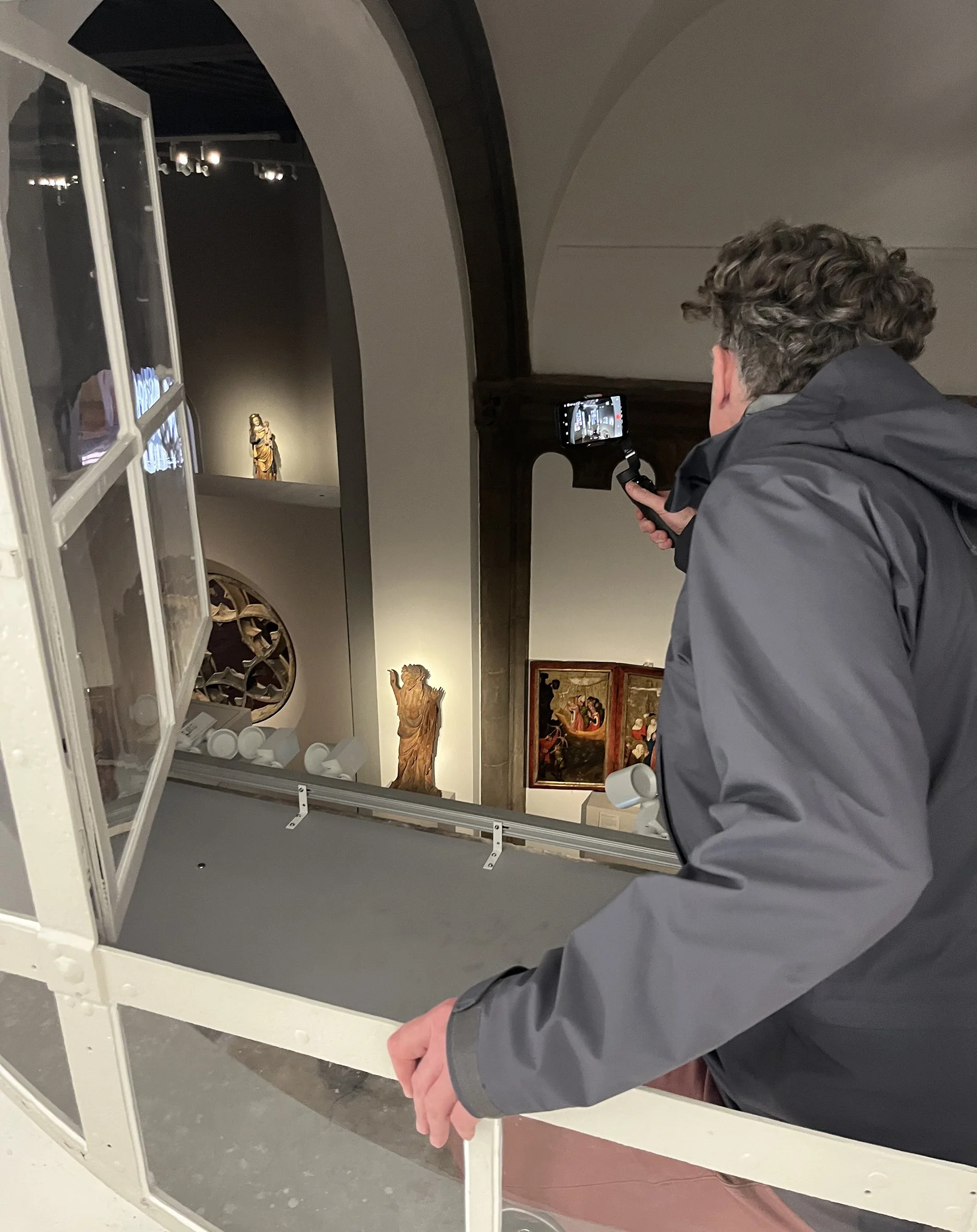 Person fotografiert Kunstwerke in einem Museum mit einem Smartphone.