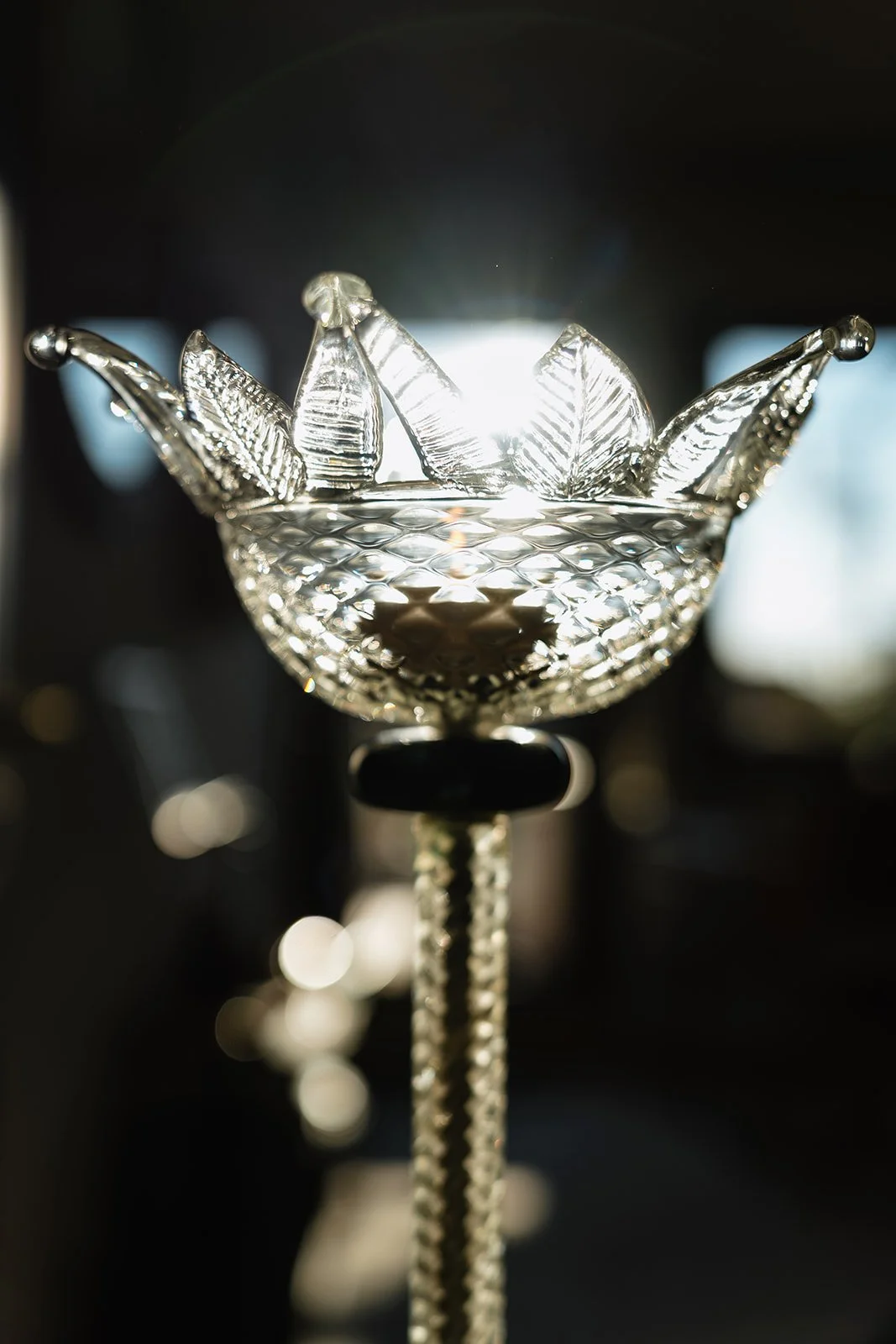 Close-up of a crystal bowl with decorative ice cubes, backlit with sunlight, creating a sparkling effect.