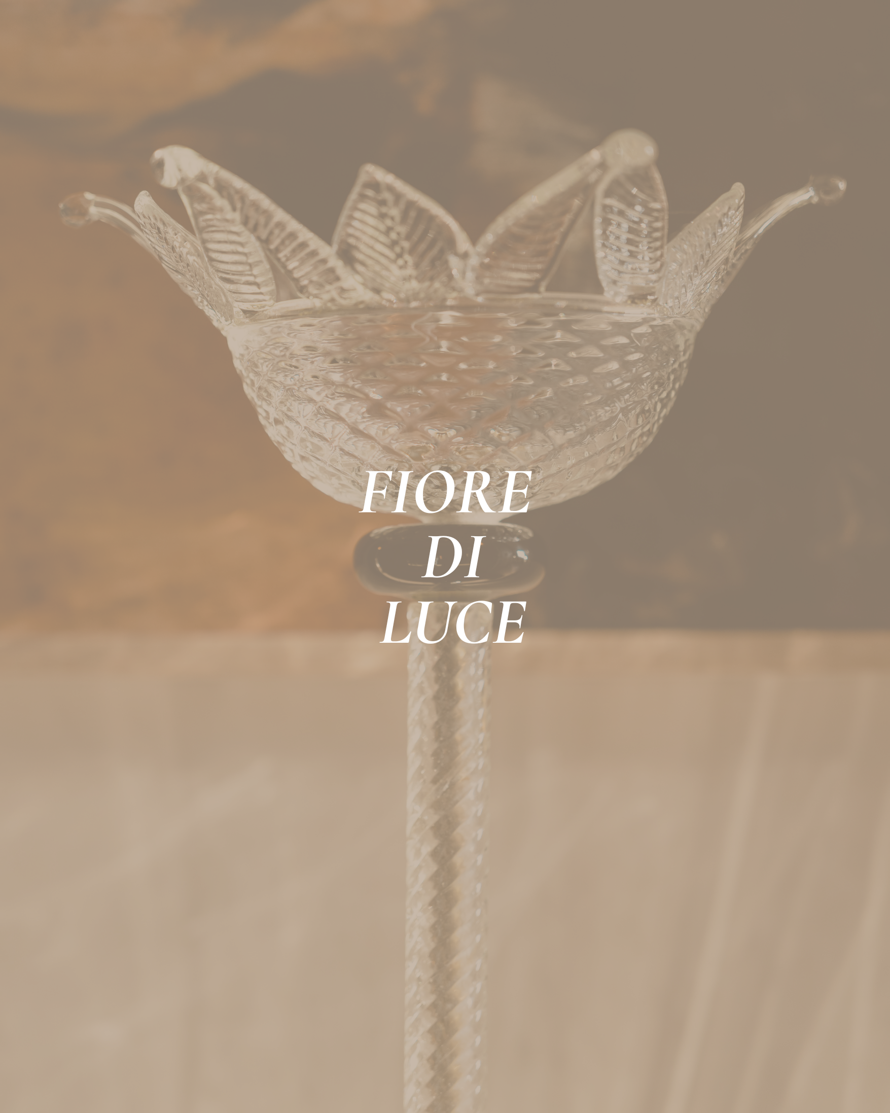 A decorative glass bowl with a textured surface and leaf-shaped details around the rim, placed on a reflective surface with the word 'FIORE' visible underneath.
