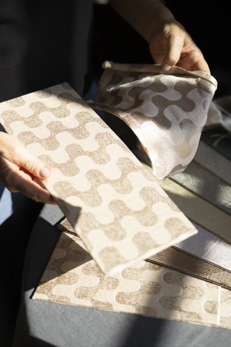 Woman presenting DOGIA lampshade in scale-patterned fabric


