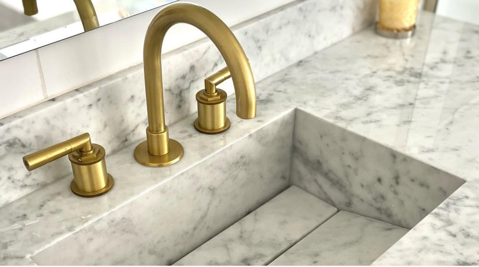 Lavabo de mármol con grifería dorada.