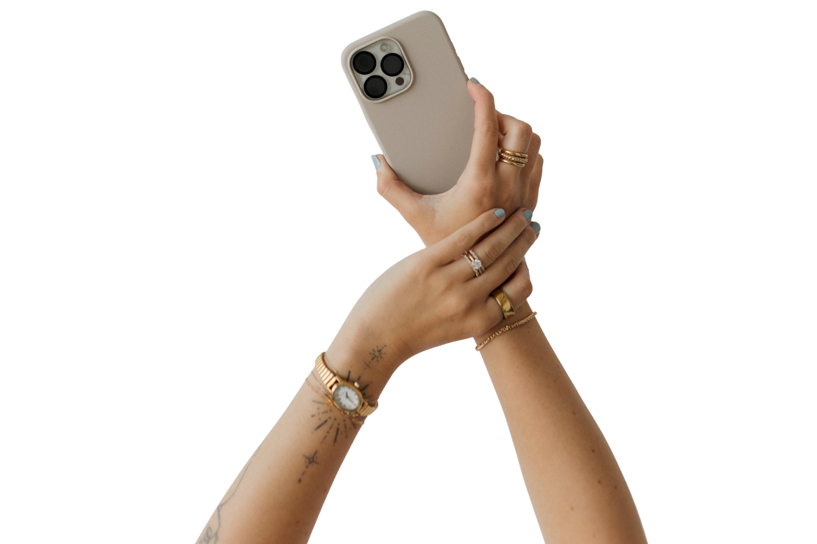 A person holding a smartphone with both hands, wearing multiple rings and a watch, with tattoos on the arms.