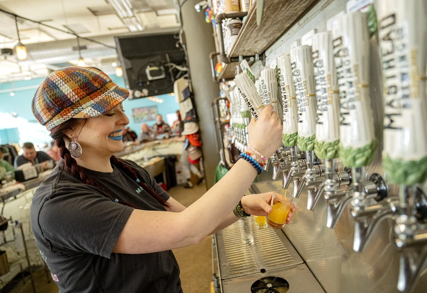 Bartender pouring a hazy beer at Masthead’s tap wall