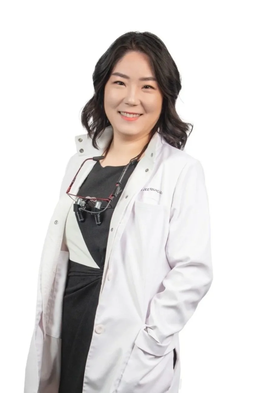 Dr. Jeeyoung Han in white doctor lab coat smiling looking at camera
