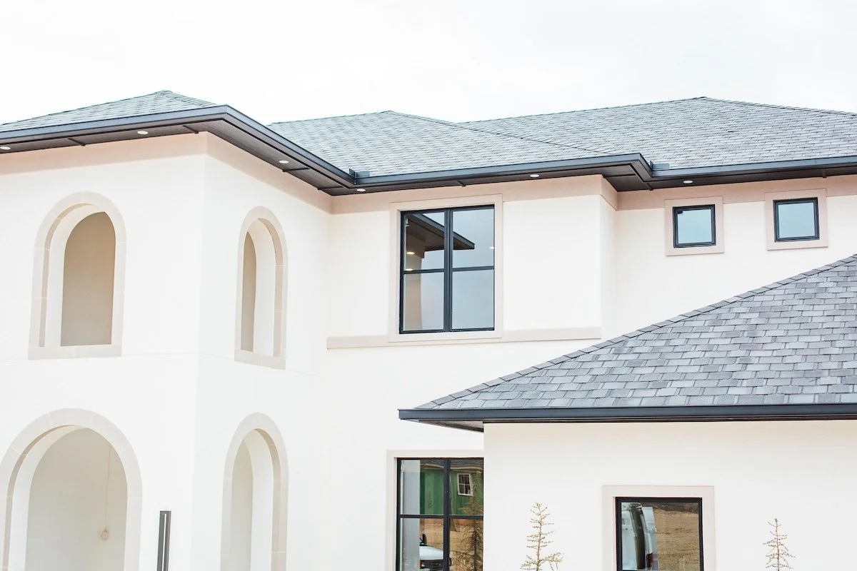 Modern two-story house with arched windows and gray shingled roof